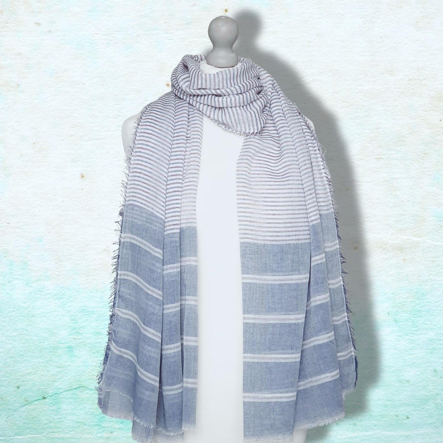 Striped scarf on a mannequin against a light blue background