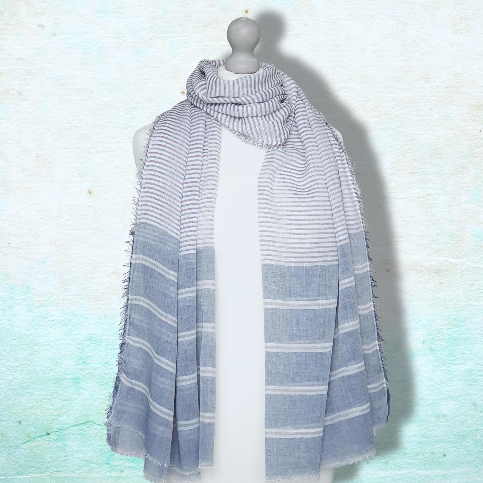 Striped scarf on a mannequin against a light blue background