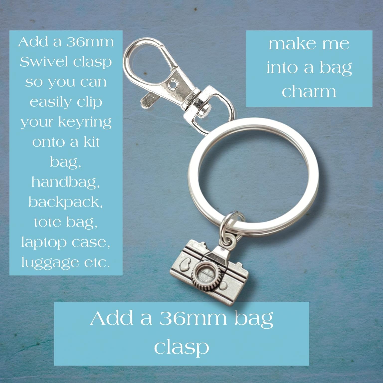 A silver metal keyring with a swivel clasp and a small camera charm, shown on a textured blue background with three light blue text boxes giving instructions for bag charms.