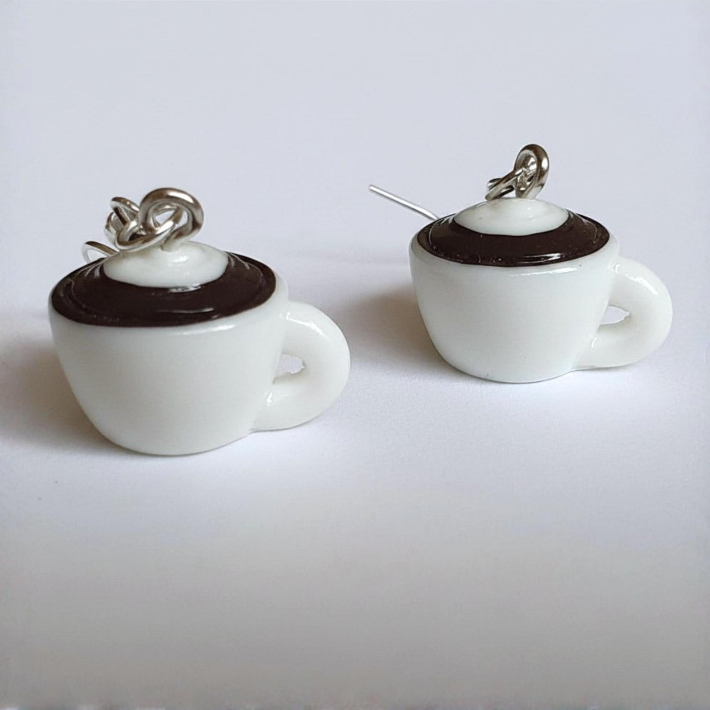 Pair of coffee cup earrings on a light grey background 