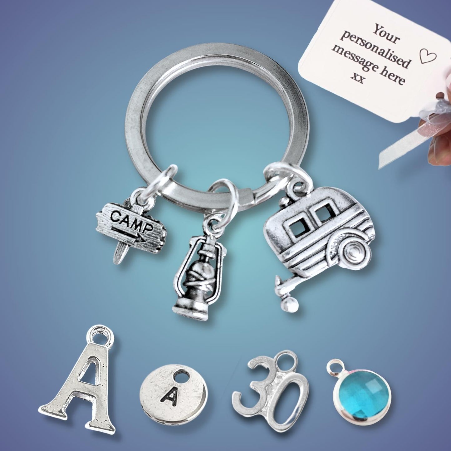 Silver keychain with caravan and camping charms on a blue background