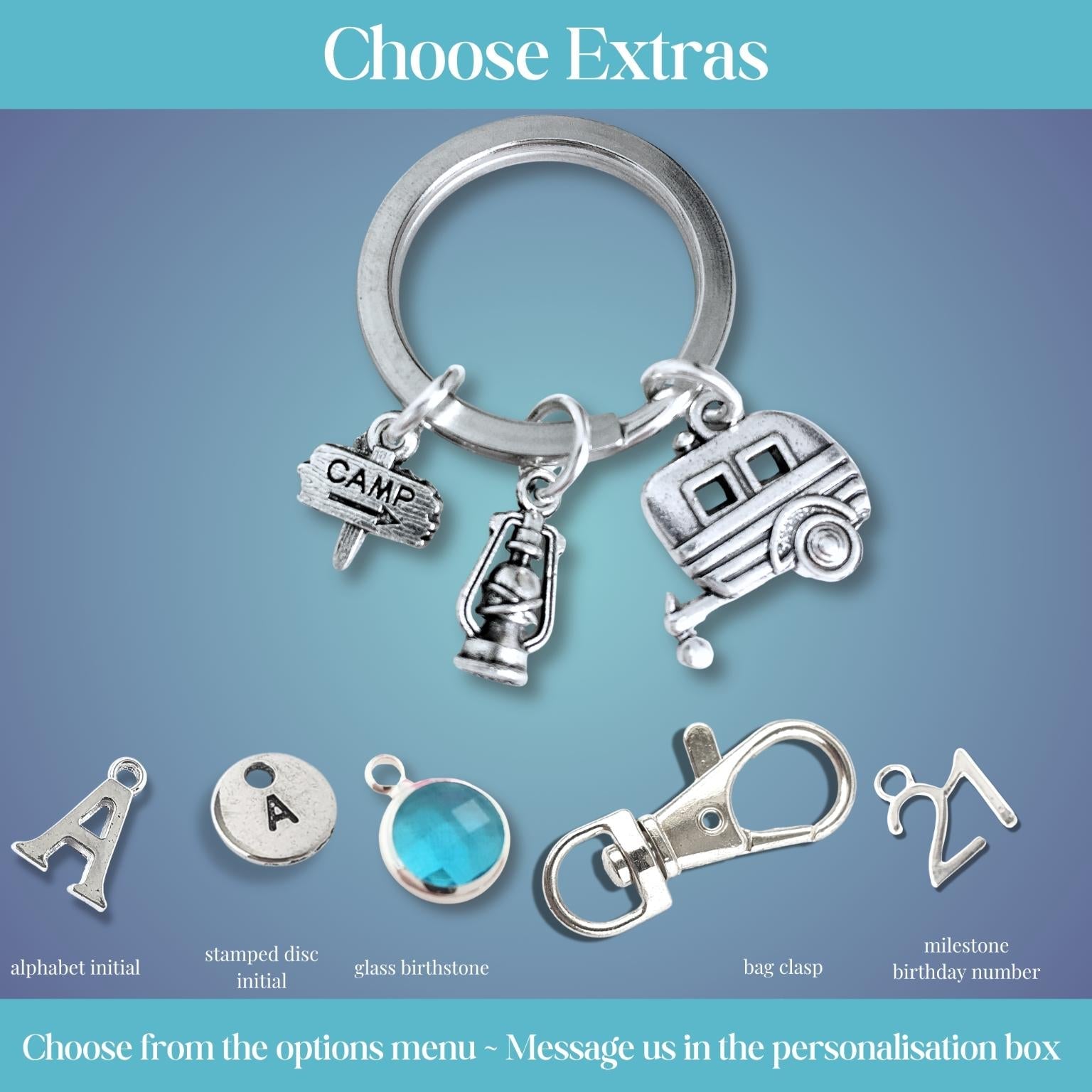 Silver keychain with caravan and camping charms on a blue gradient background