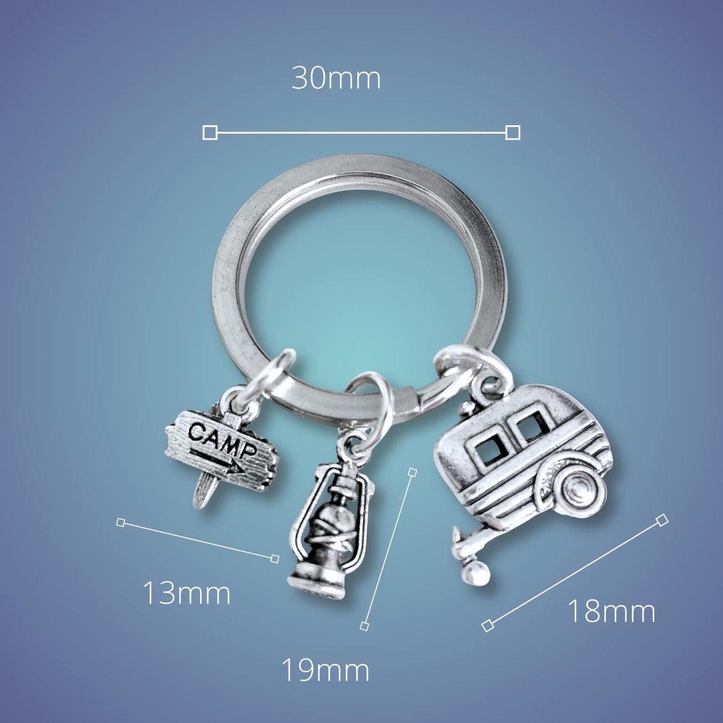 Silver keychain with camping-themed charms on a blue background