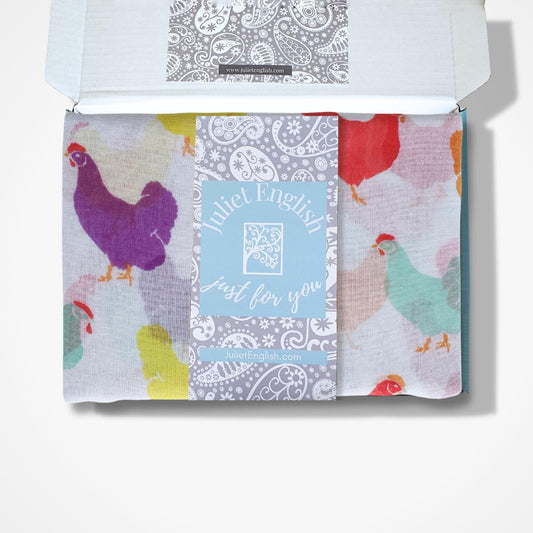 Gift boxed scarf with colourful chicken patterns on a white background
