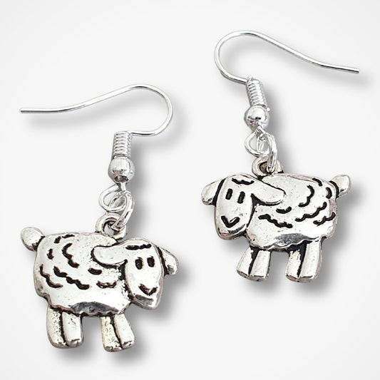 Silver sheep-shaped earrings on a white background