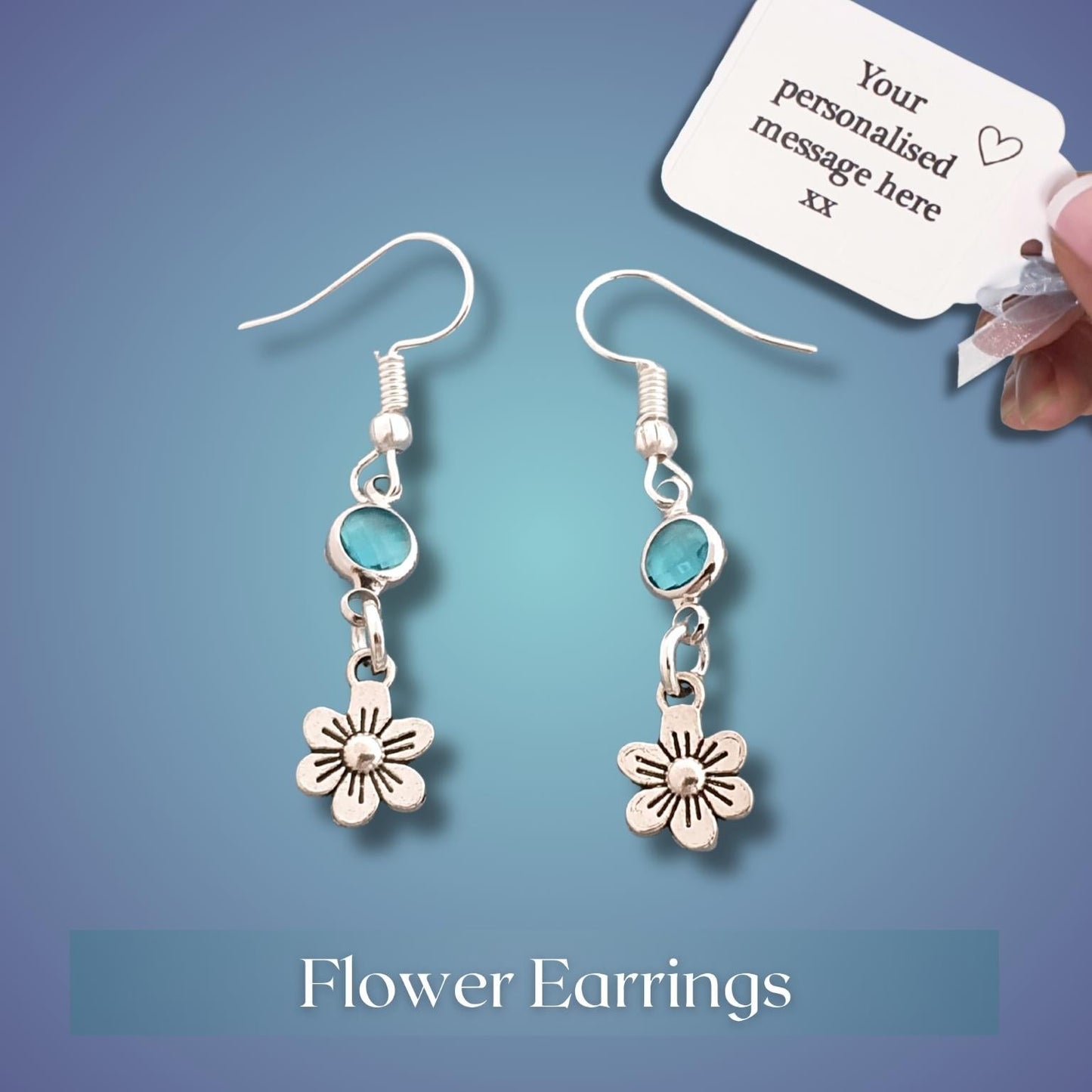 Flower earrings with a customizable message tag on a blue background