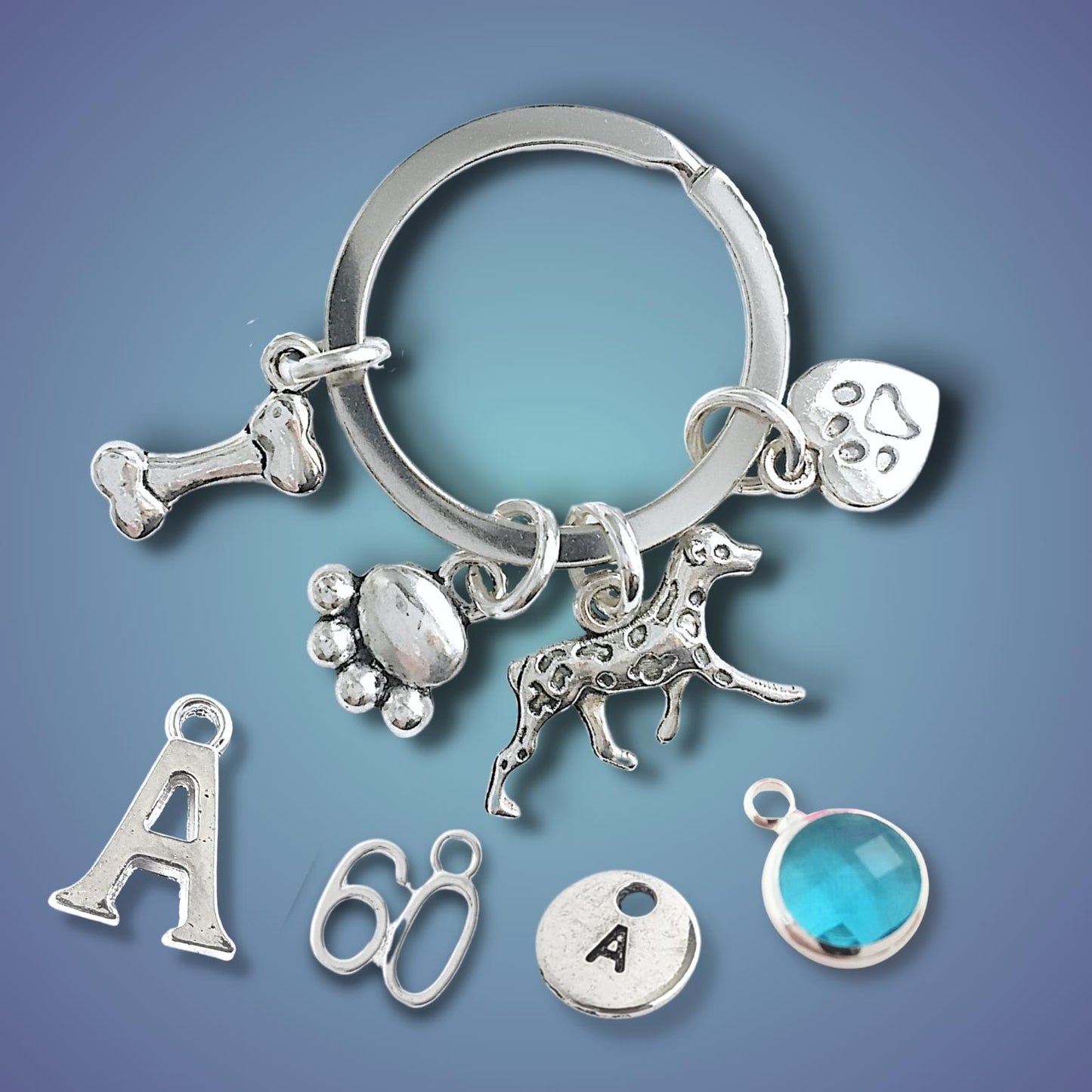 Silver keychain with various charms on a blue gradient background