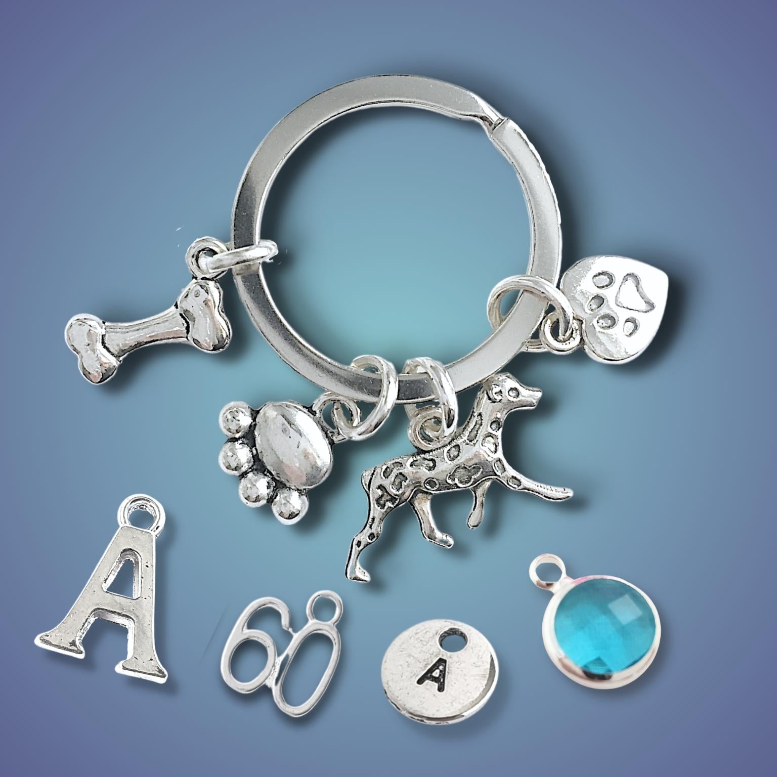 Silver keychain with various charms on a blue gradient background