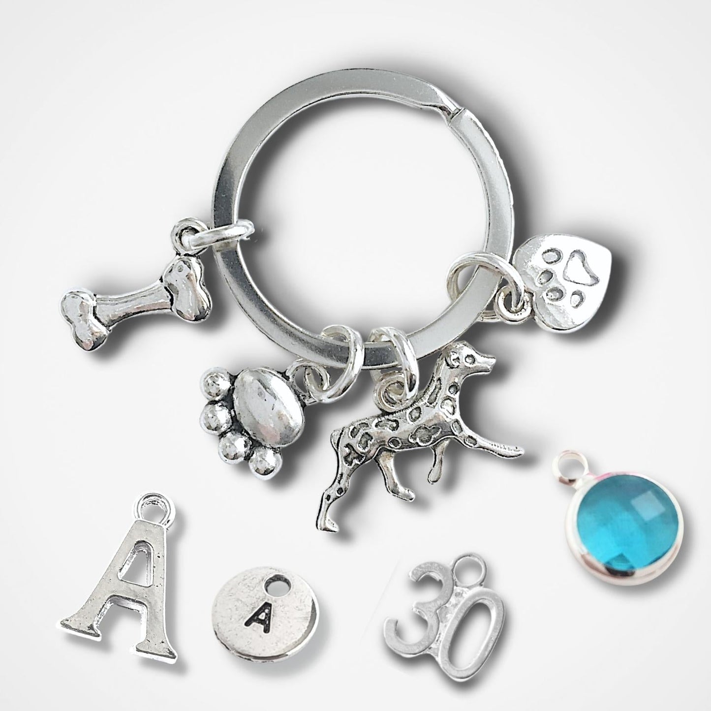 Silver keychain with various charms on a white background