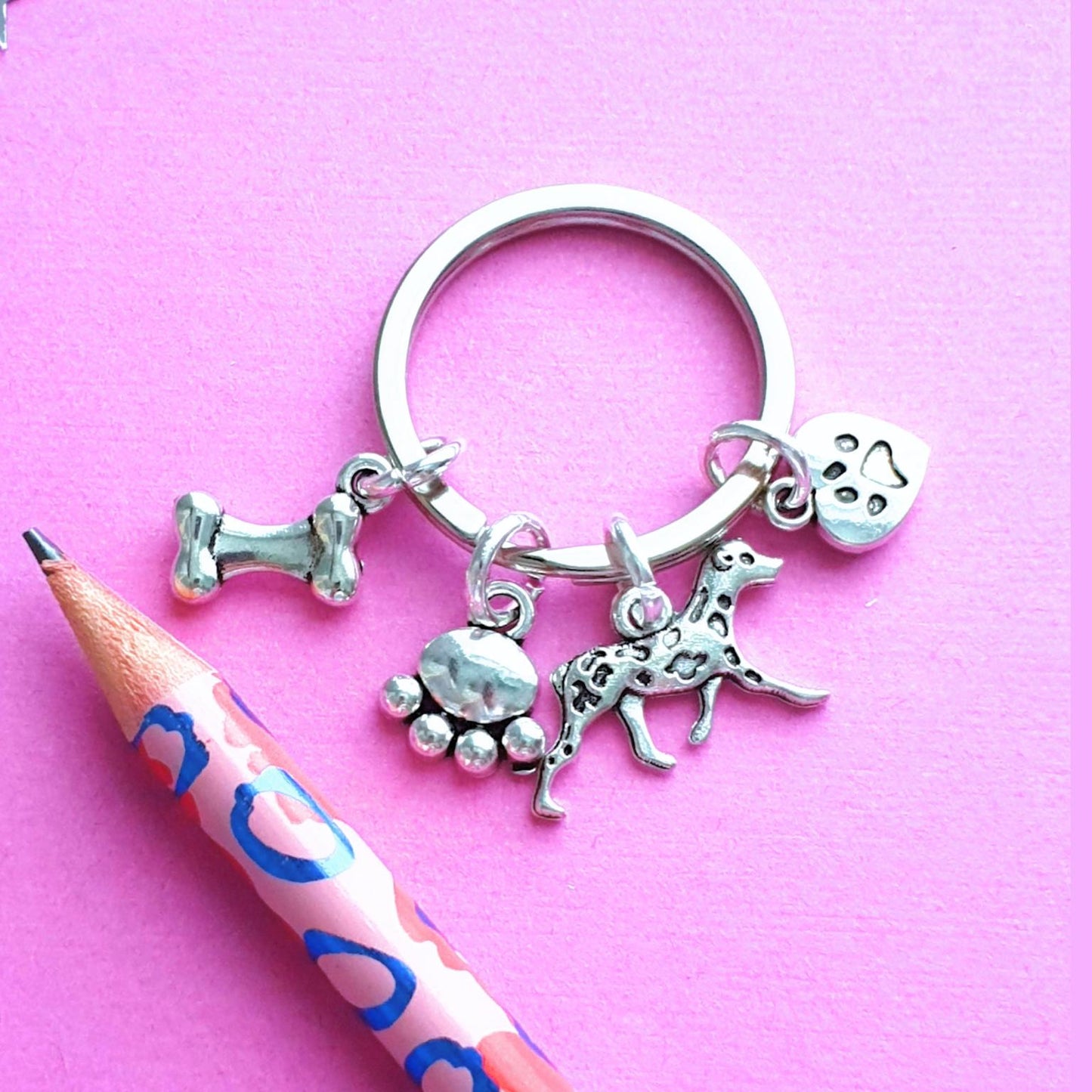 Keychain with dog-themed charms on a pink background