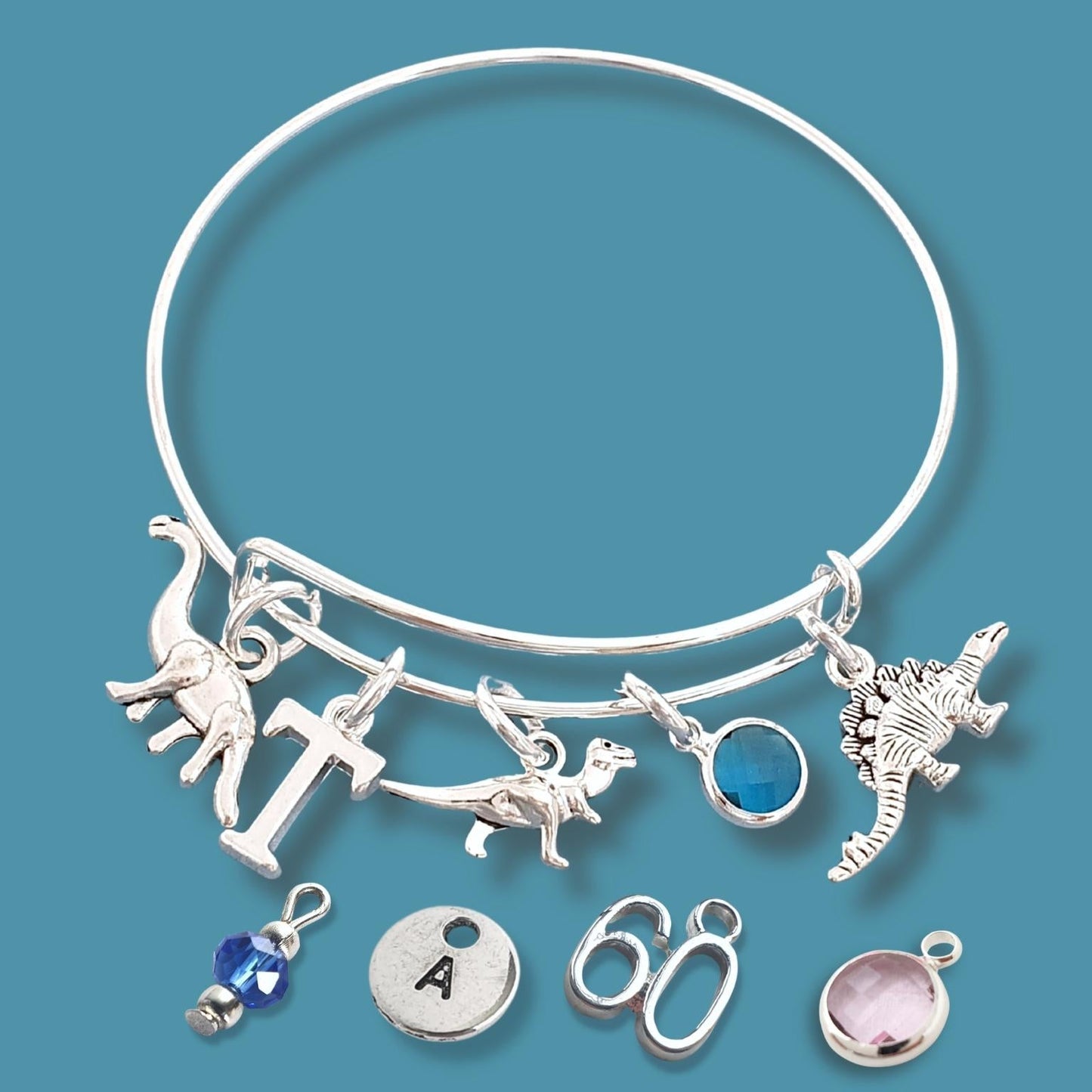 Silver bracelet with various charms on a blue background