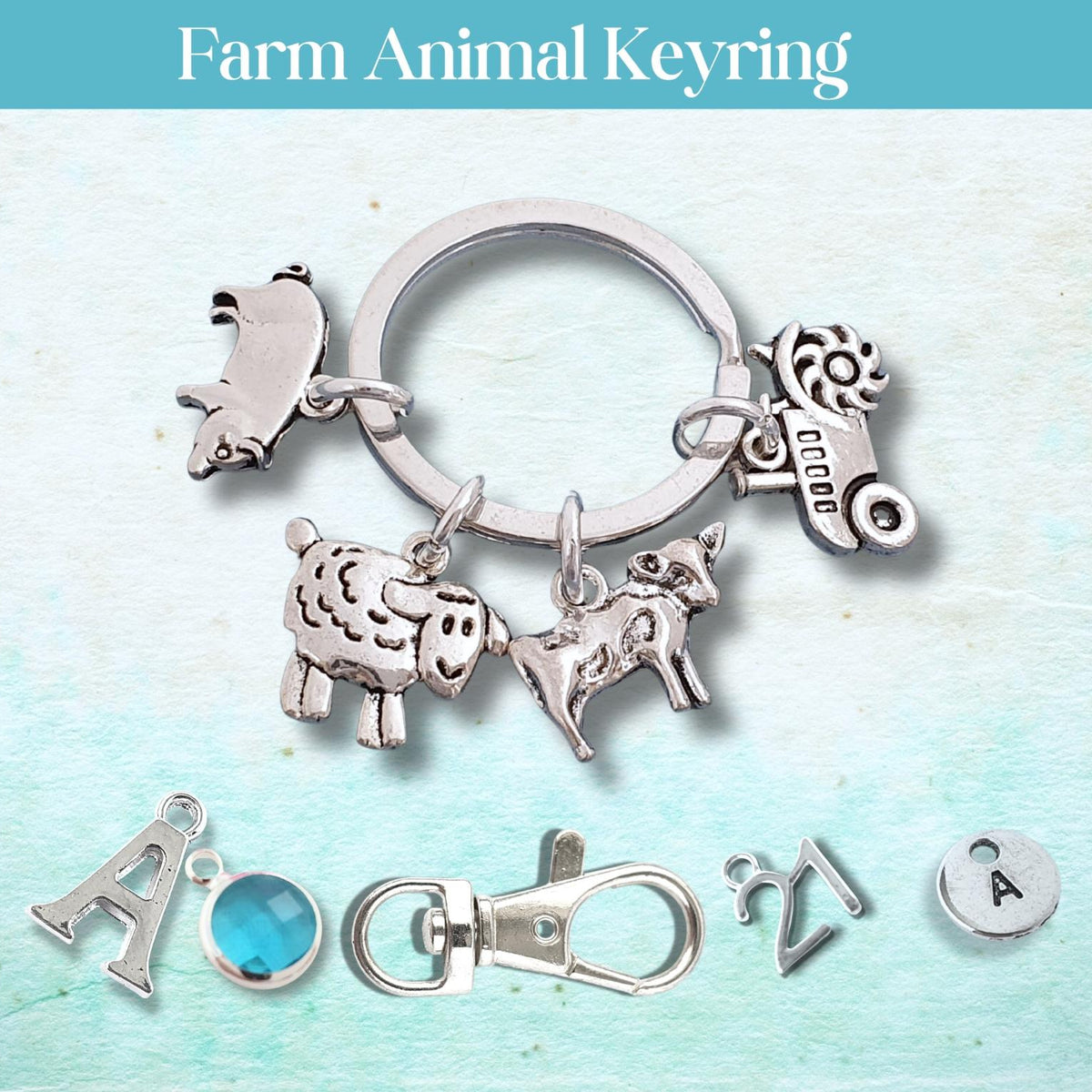 A silver-toned farm animal keyring charm set displayed on a light blue textured background with a teal header reading 'Farm Animal Keyring.' The set includes a sheep, a pig, a tractor, a cow, and small letter charms, with one blue oval charm shown separately below the main keyring.