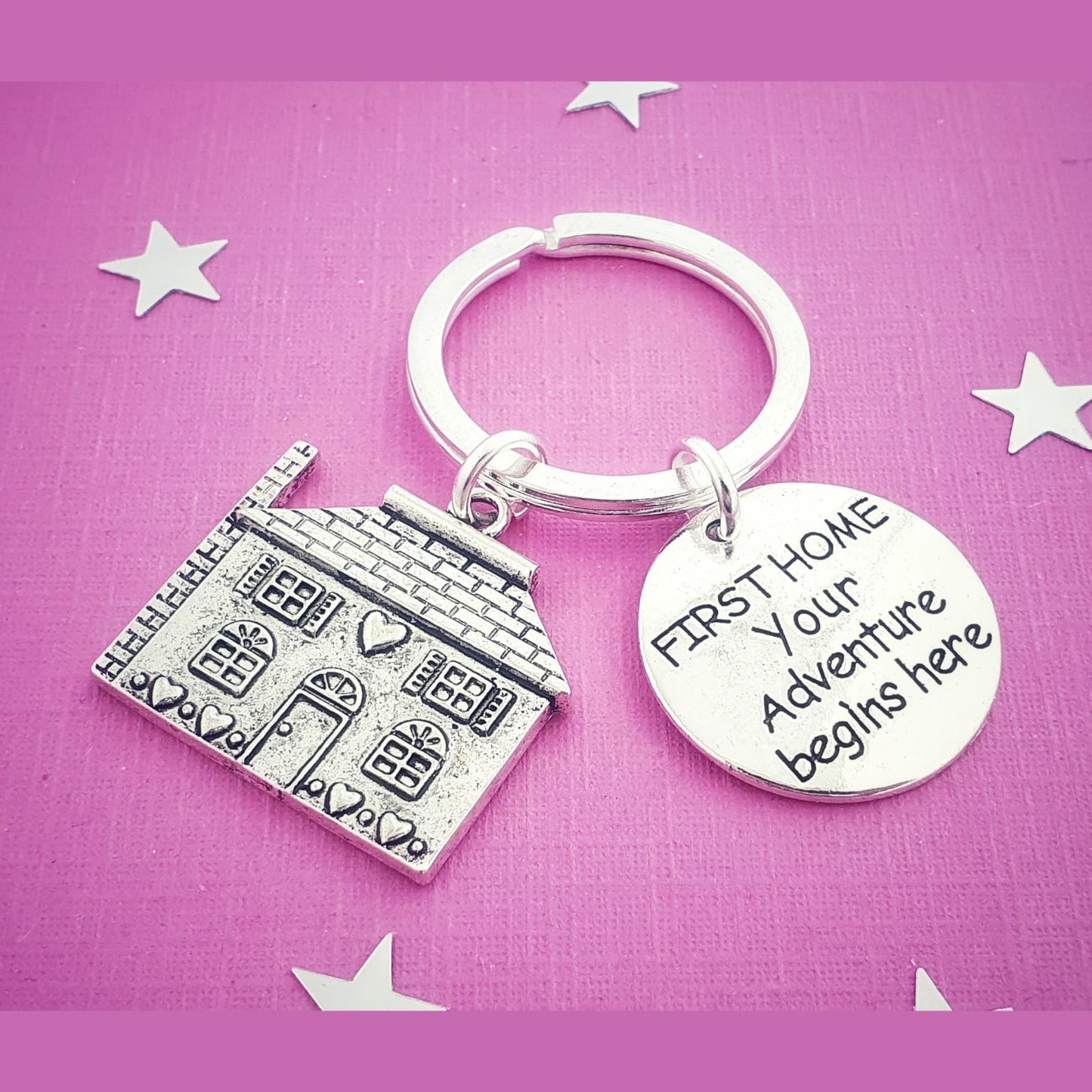 Keychain with house charm and motivational quote on a pink background