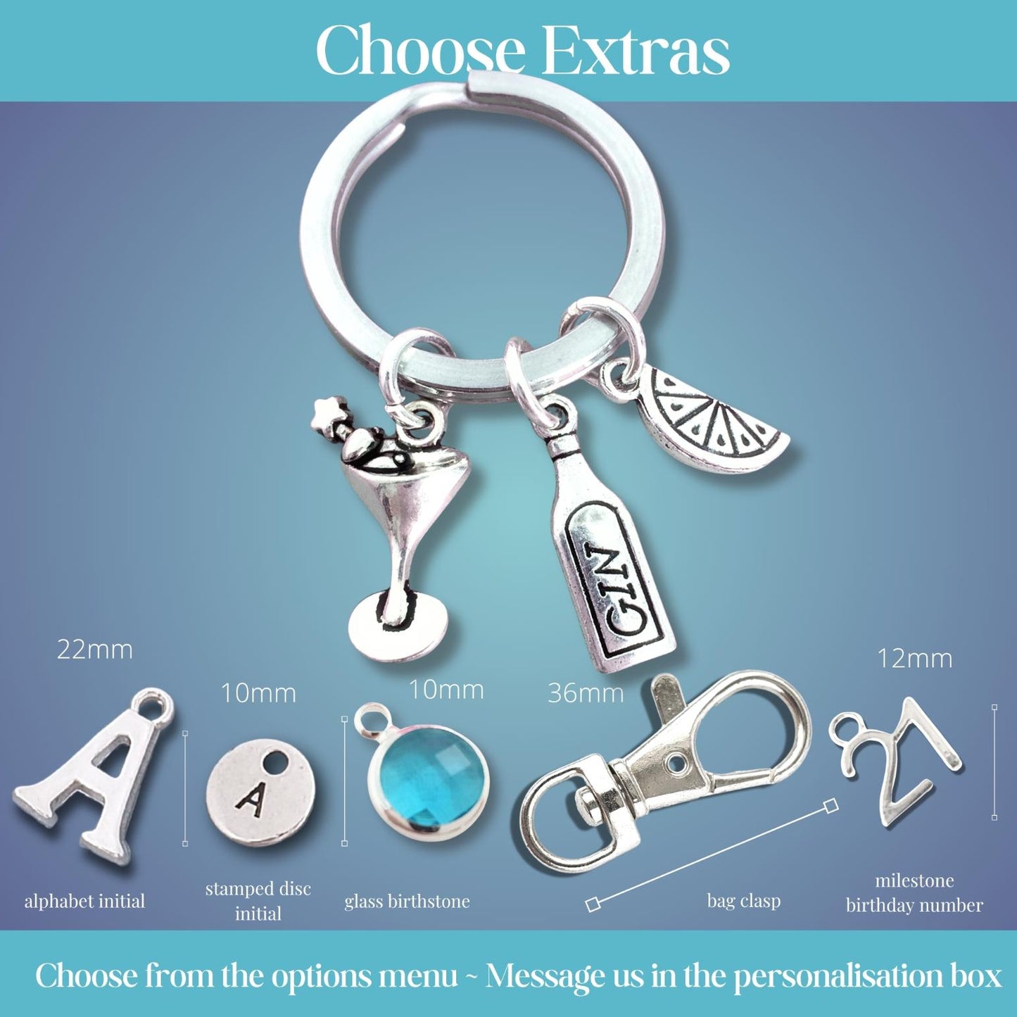 A silver keychain set displayed on a blue gradient background with text options for personalization extras. The keychain includes a large split ring, a martini glass charm, a gin bottle charm, and a lemon slice charm.