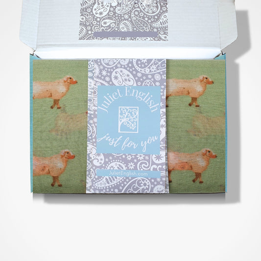 Scaarf with sheep design in a box and 'Juliet English' branding on a white background
