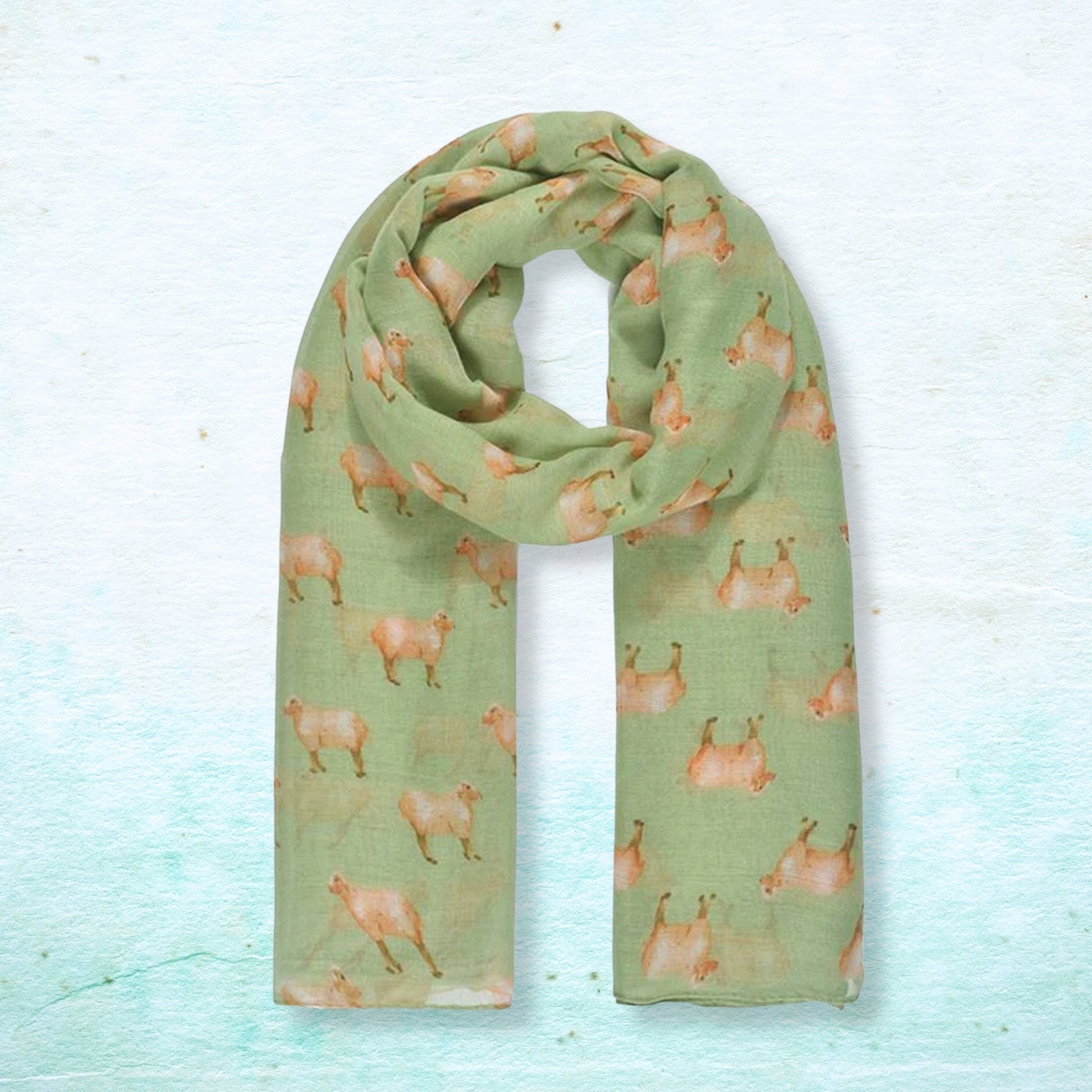 Green scarf with sheep pattern on a light blue background