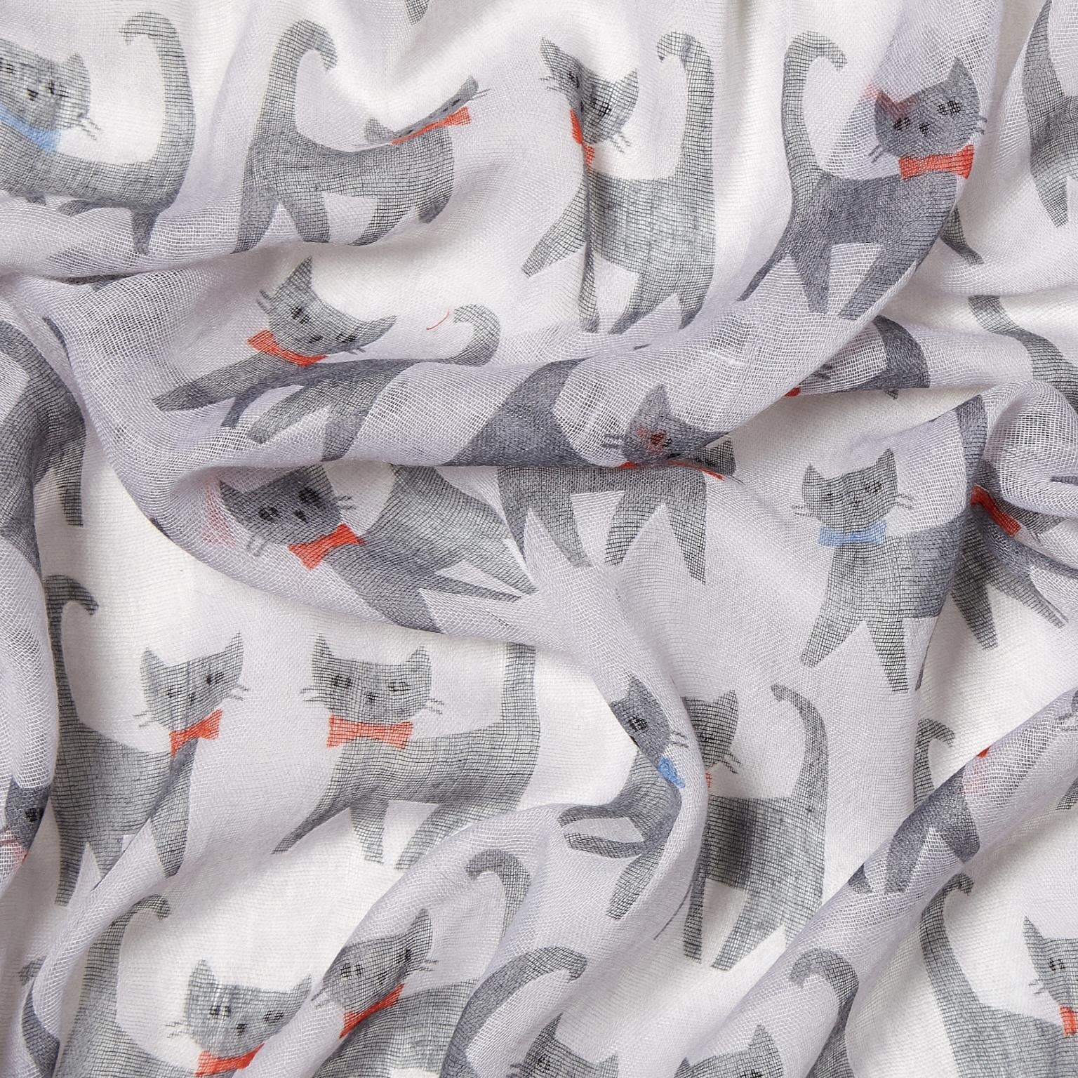 grey scarf printed with a pattern of grey cartoon cats wearing red and blue bowties, draped in soft folds.