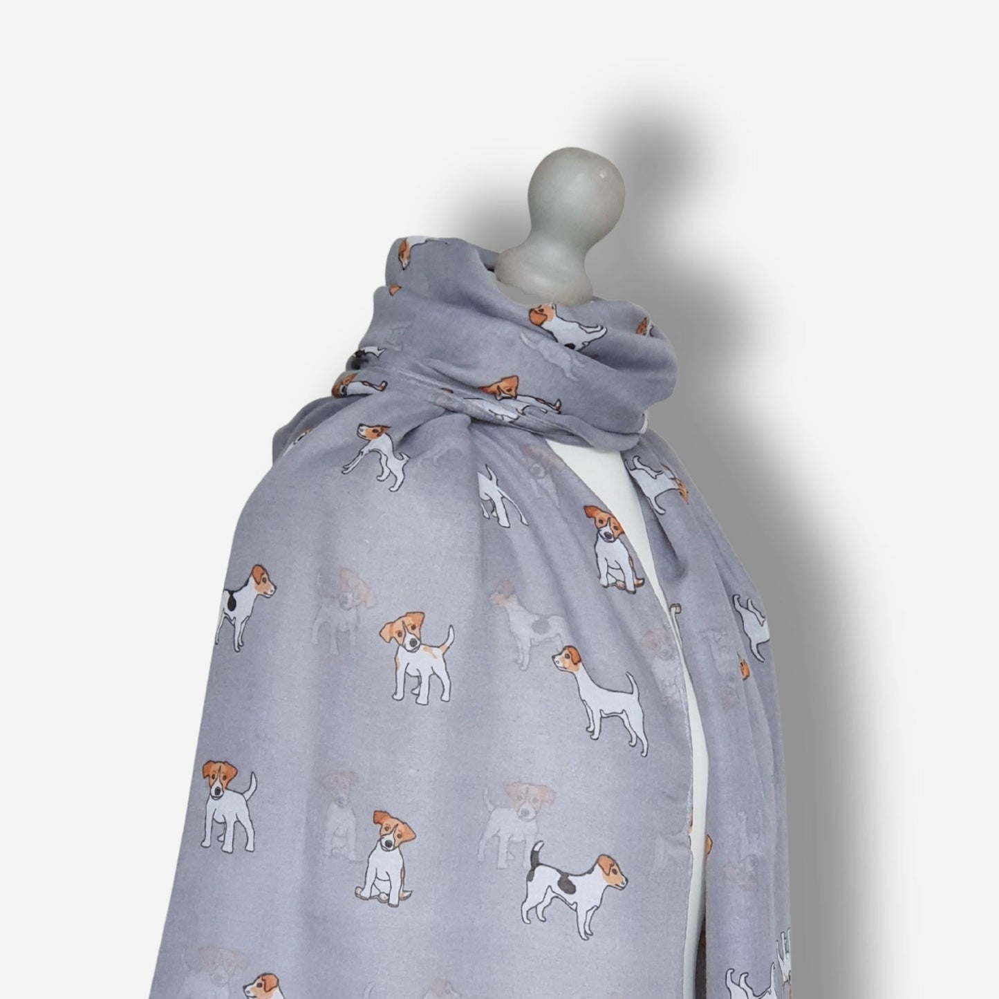 Grey scarf with jack russell dog pattern on a mannequin against a white background
