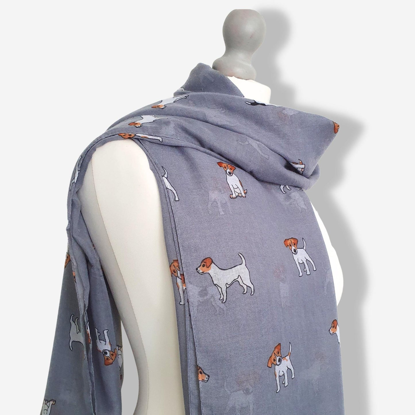 Grey scarf with jack russell dog pattern on a mannequin against a white background