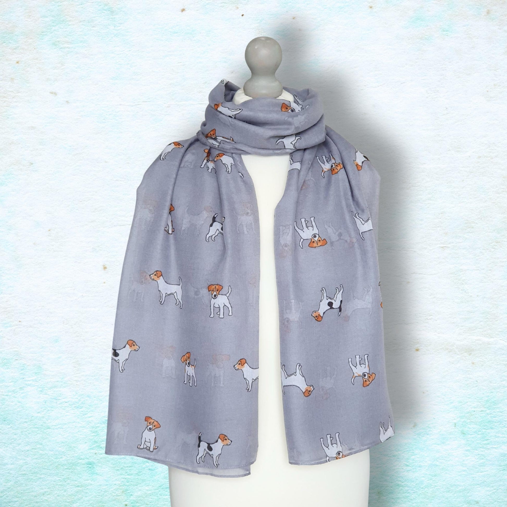Grey scarf with jack russell dog pattern on a mannequin against a light blue background