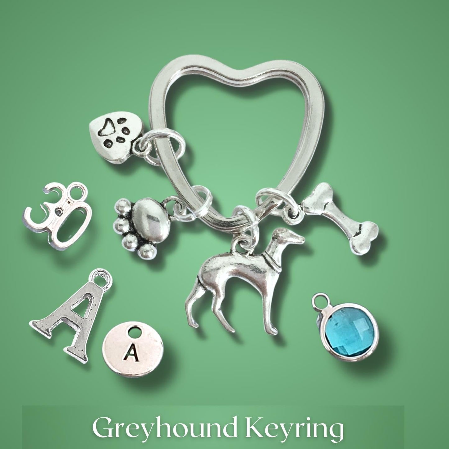 Silver keyring with dog-themed charms on a green background