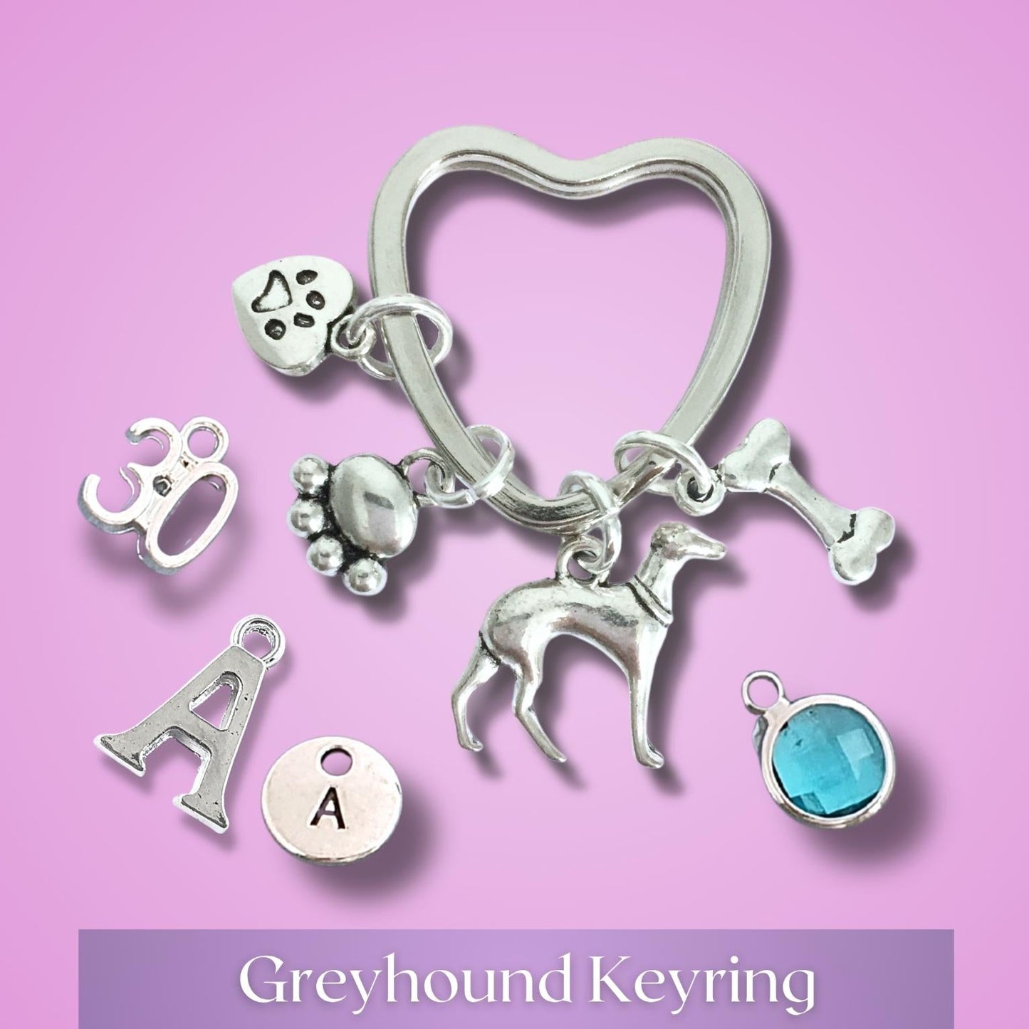 Silver keyring with various charms on a pink background