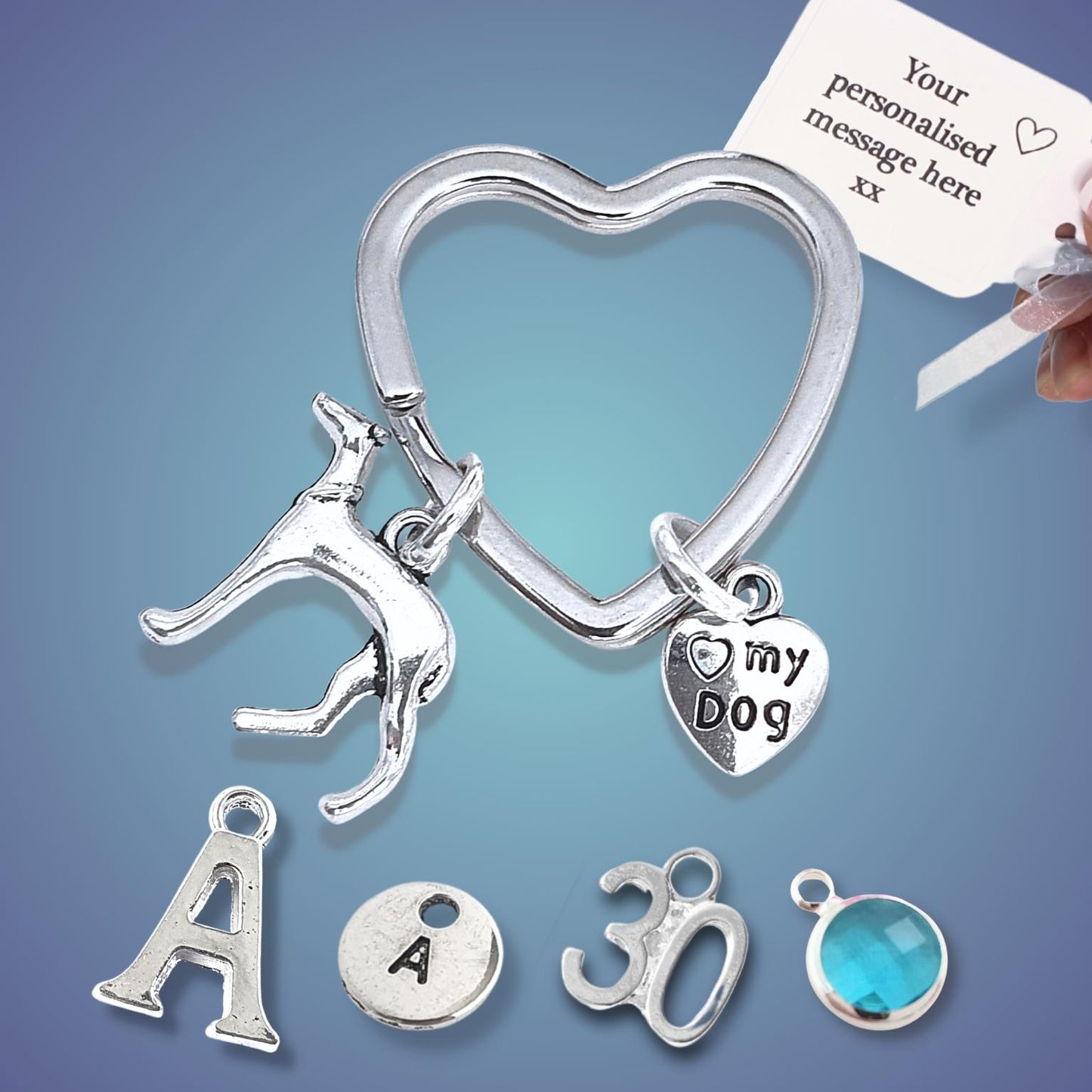Silver heart-shaped keychain with dog charm and other charms on a blue background