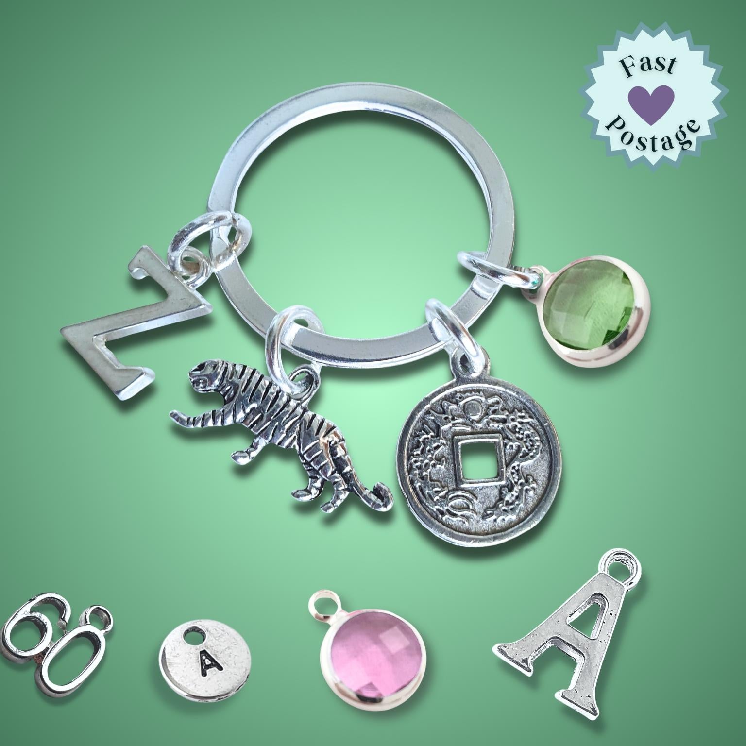 Silver keychain with various charms on a green background