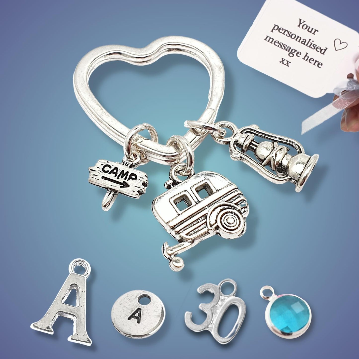 Silver keychain with various camping charms on a blue background