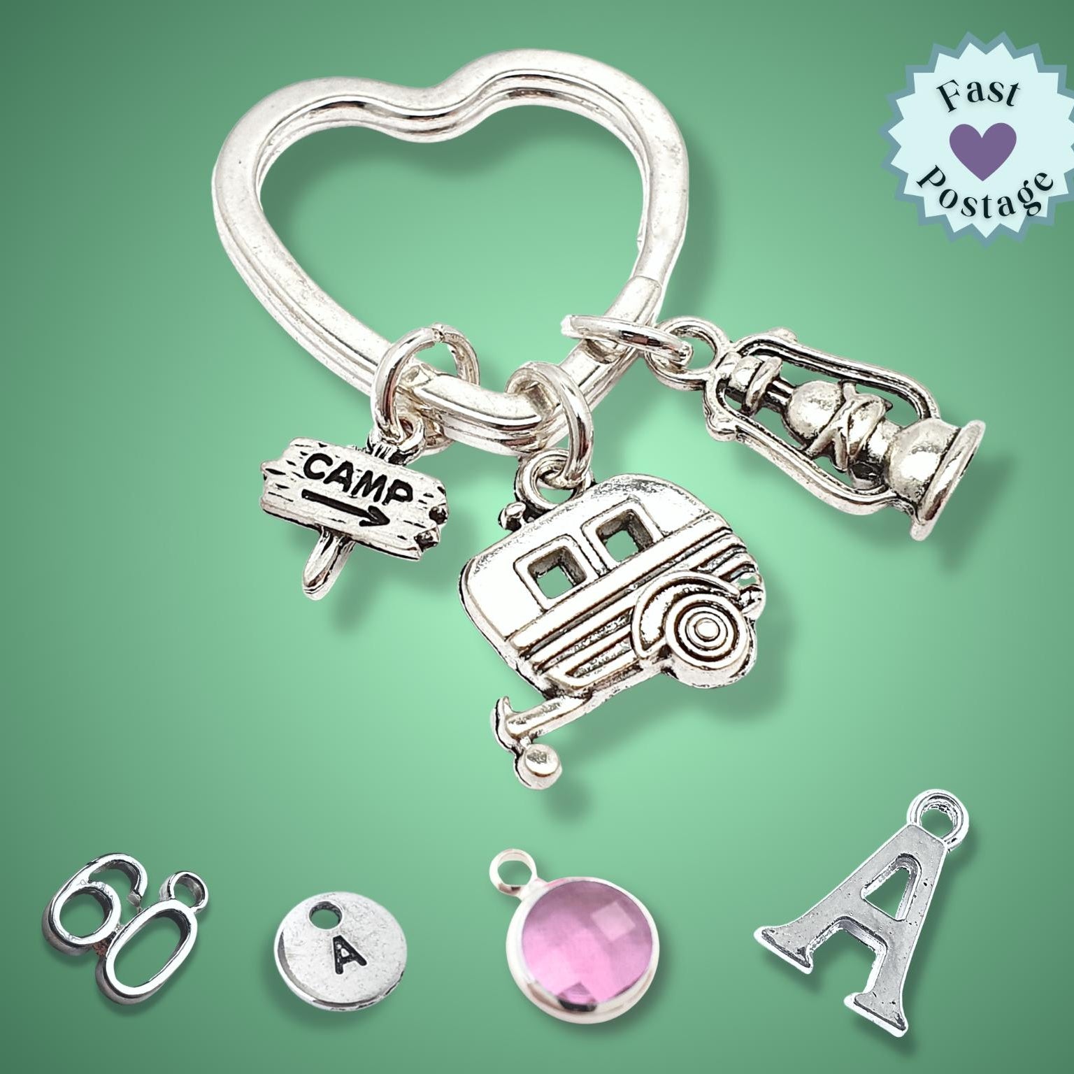 Silver keychain with various camping charms on a green background