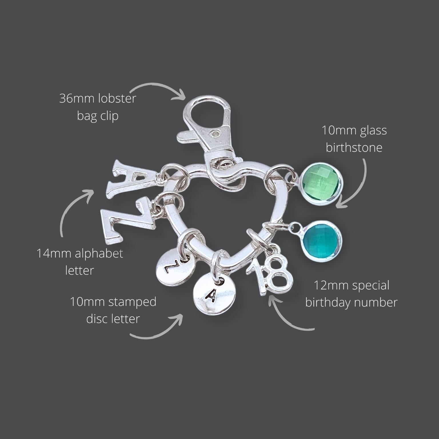 Silver keyring with various charms on a gray background