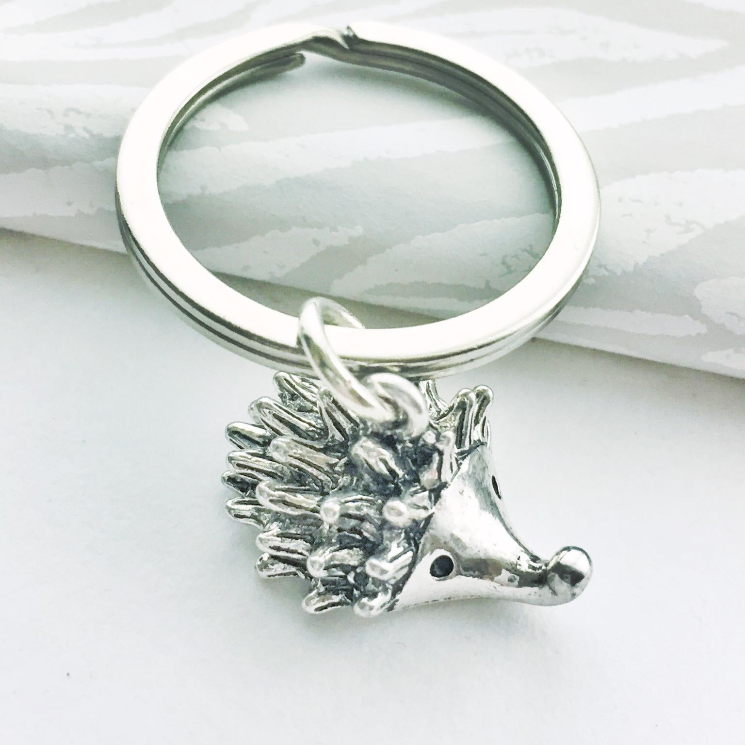 Silver hedgehog keychain on a white background