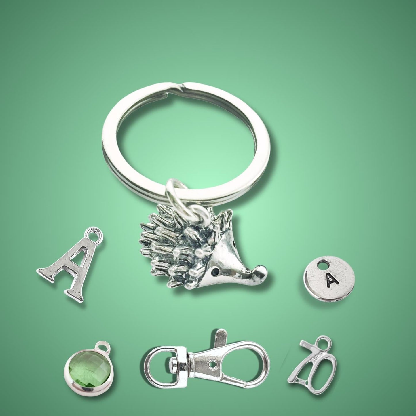 Silver hedgehog keychain with various charms on a green background