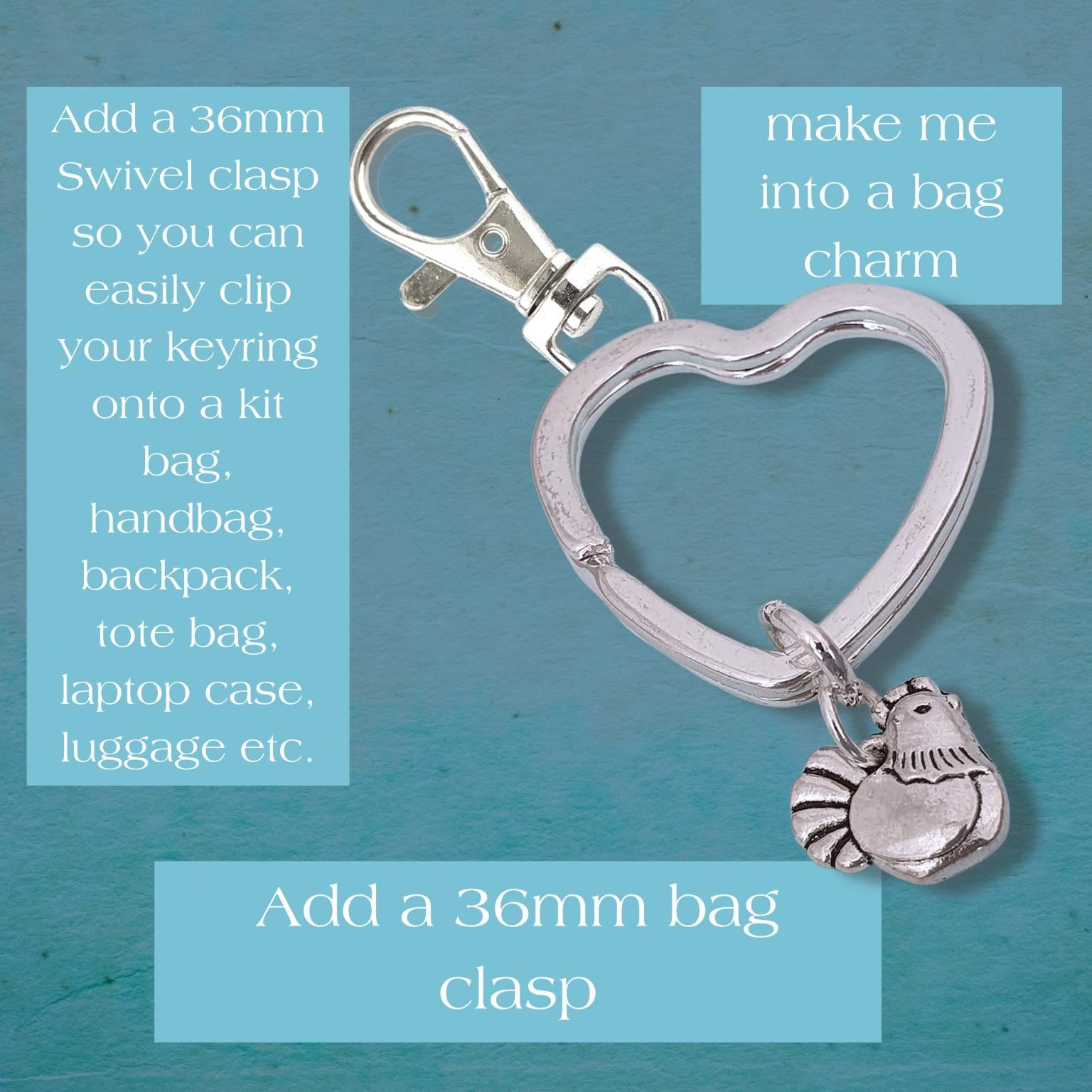 Silver heart-shaped keyring with a small hen charm, shown on a textured teal background with three light blue text boxes containing product assembly and attachment instructions.