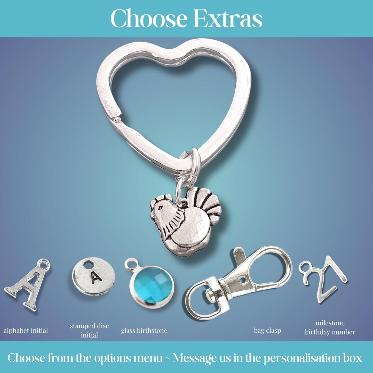 A promotional graphic showing a silver heart-shaped clasp with a small hen charm, plus several customizable extra options labeled alphabet initial, stamped date initial, glass birthstone, bag charm, and milestone birthday number on a blue gradient background with the heading 'Choose Extras'.