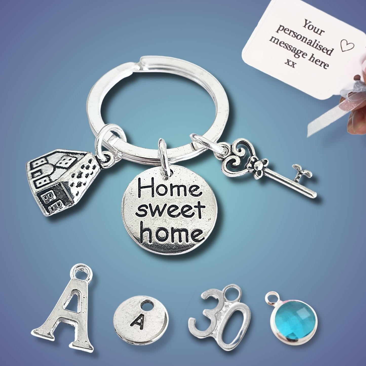 Silver keychain with 'Home sweet home' charm and other charms on a blue background