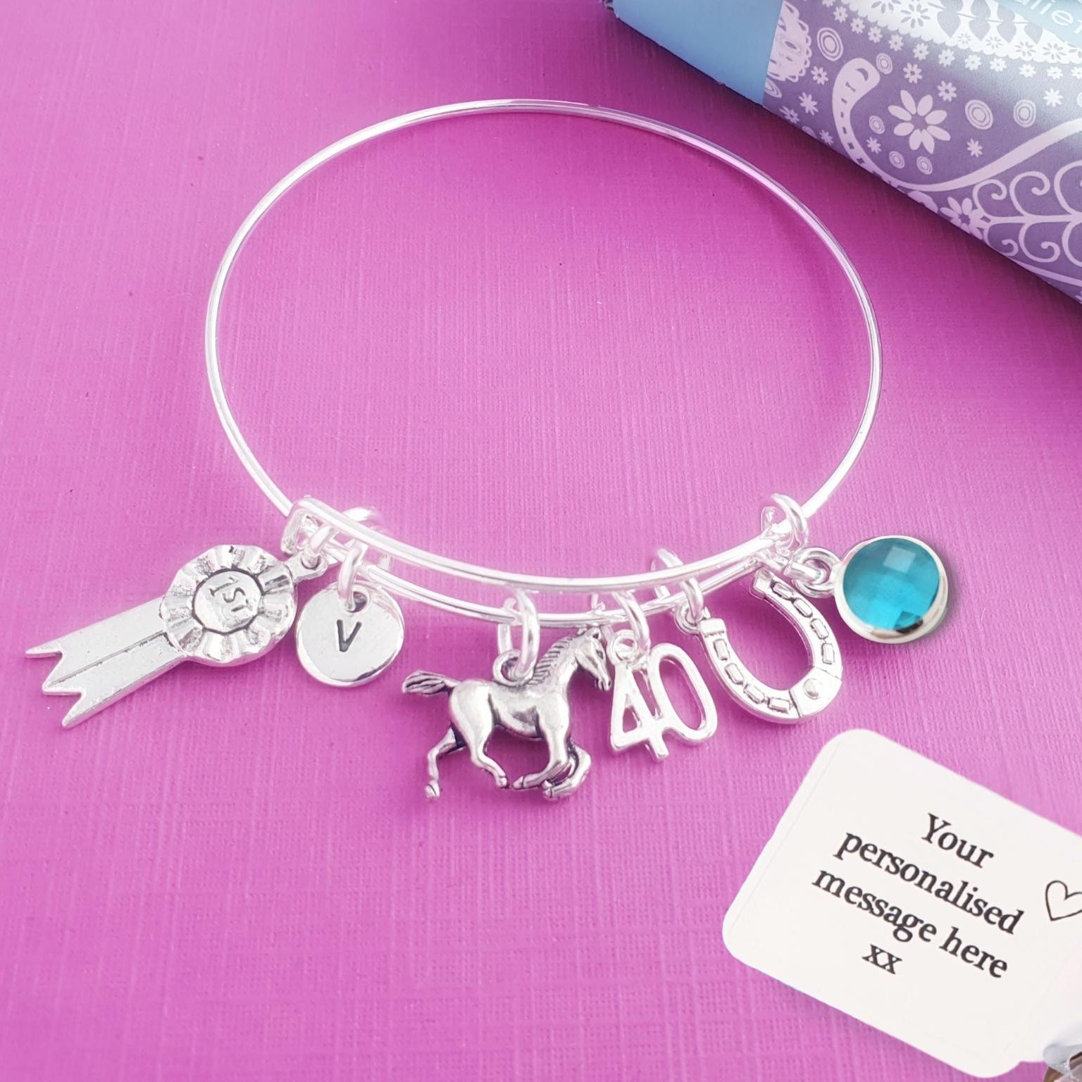 Silver bracelet with horse charms on a purple background