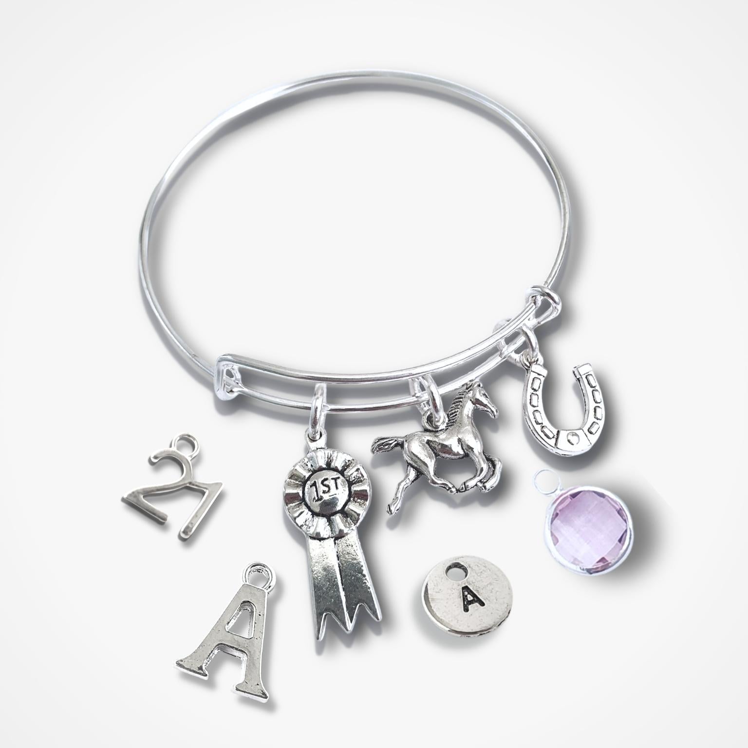 Silver bracelet with various charms on a white background