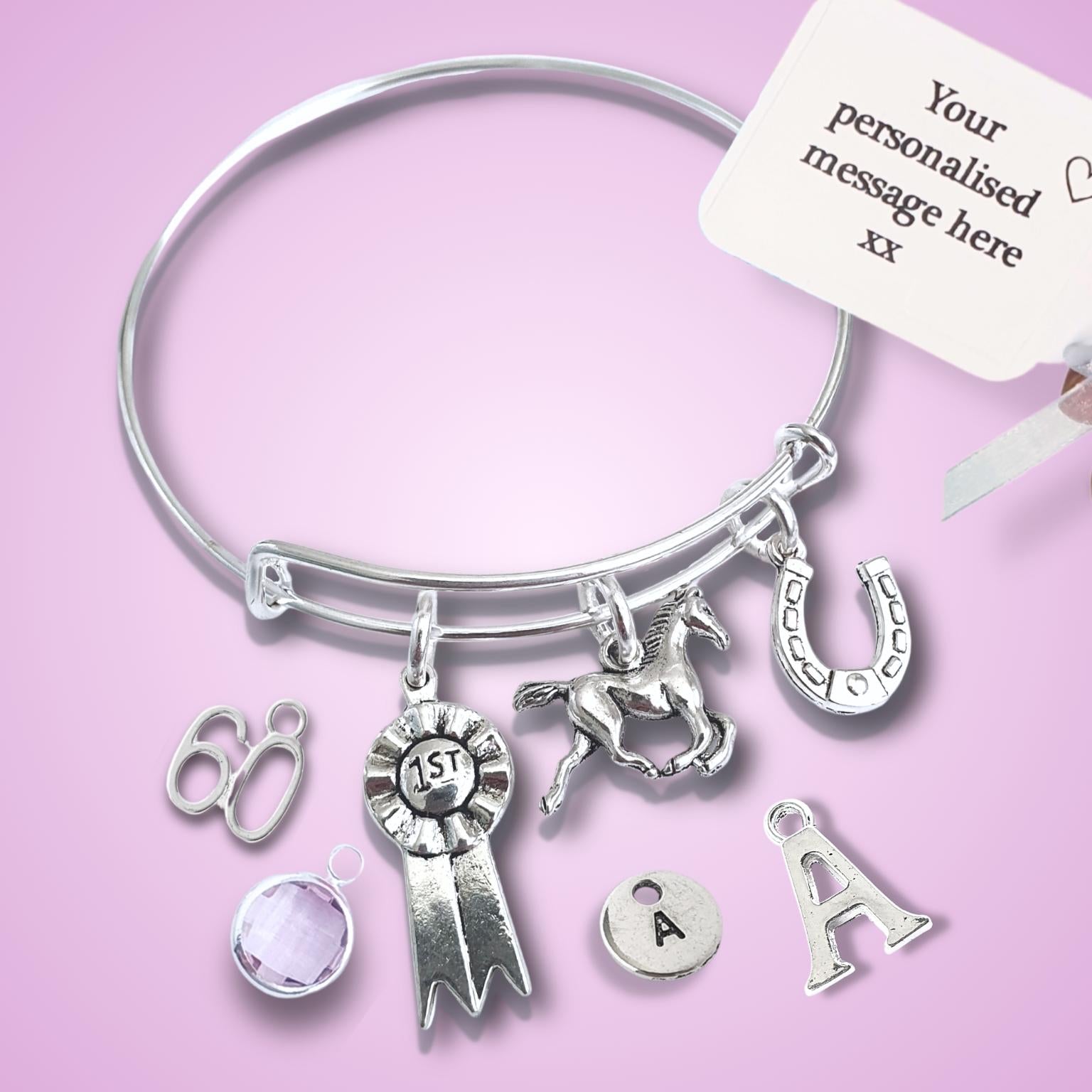 Silver bracelet with charms on a pink background