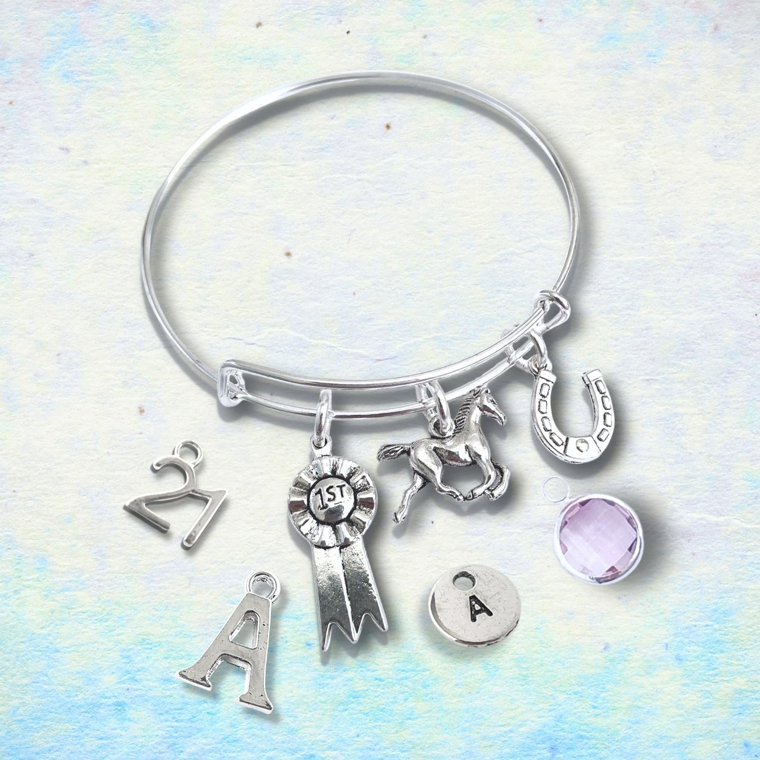 Silver bracelet with horse charms on a light blue and white background
