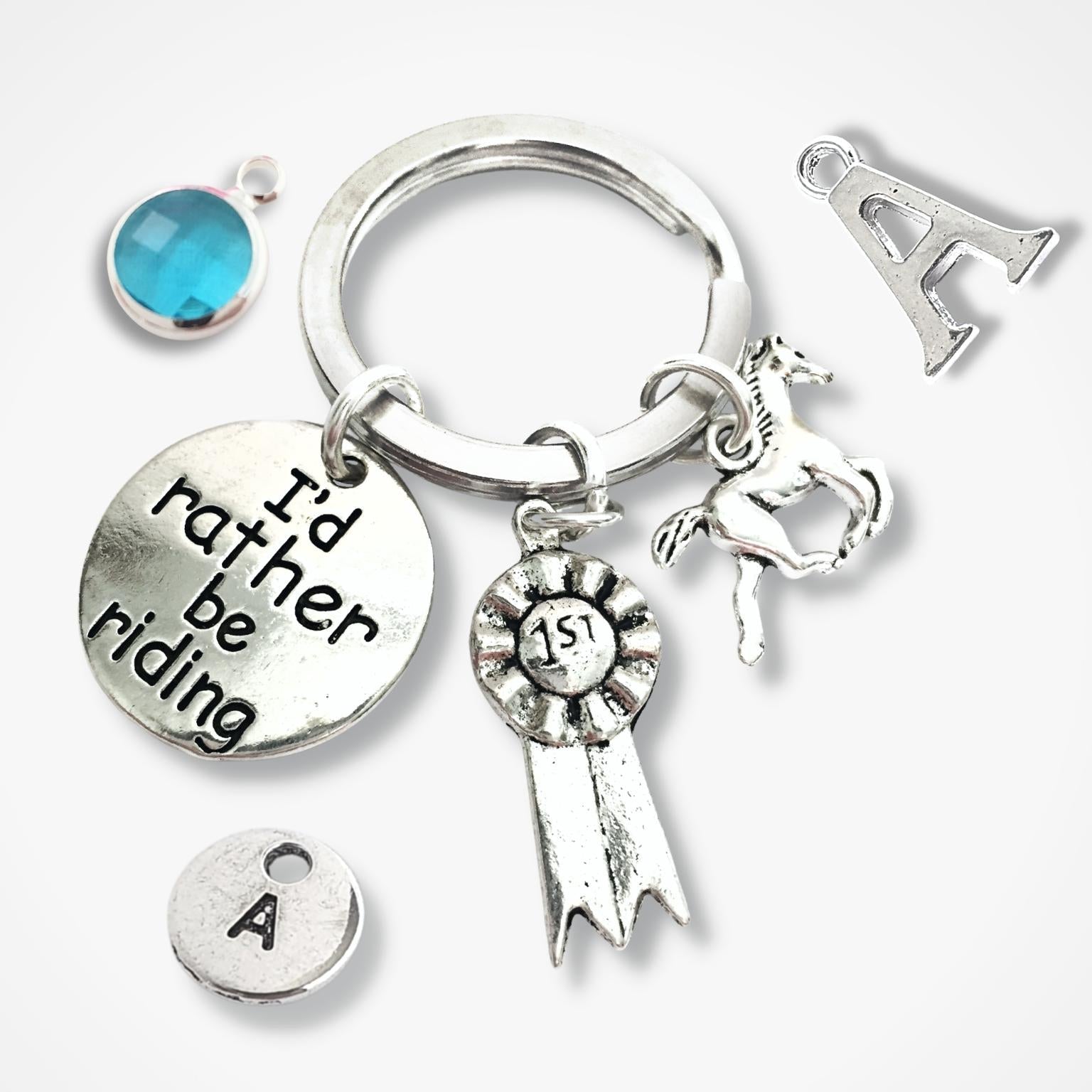 Silver keychain with various charms including a horse, letter 'A', and 'I'd rather be riding' tag.