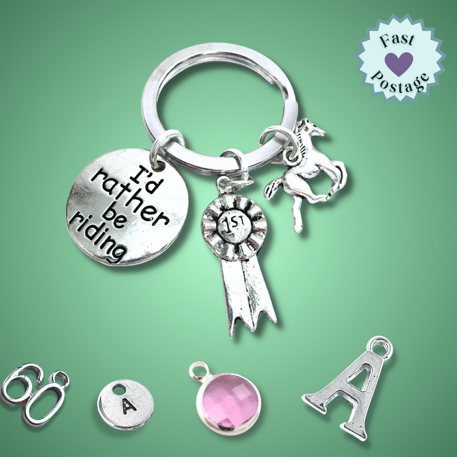 Silver keychain with horse-themed charms on a green background