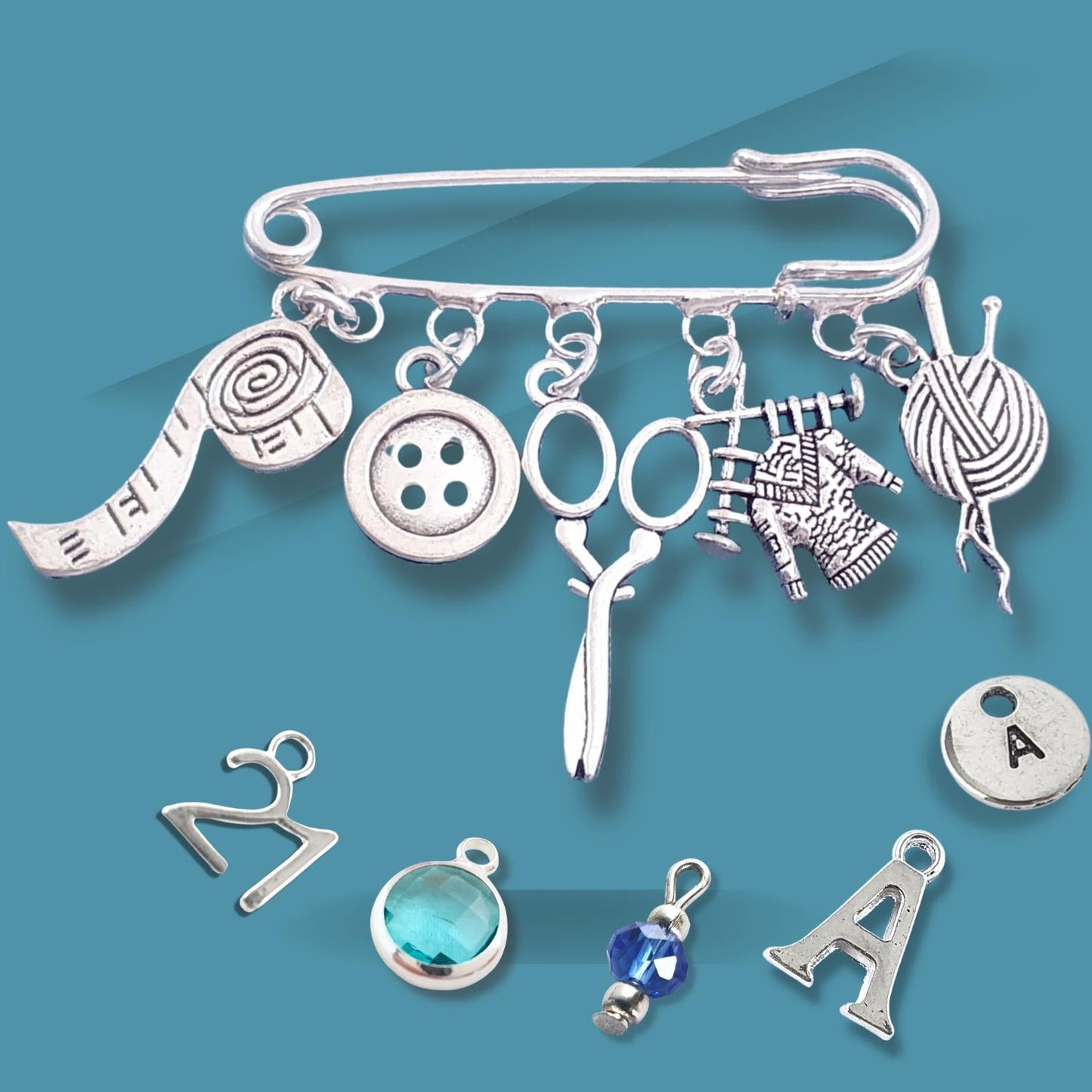 Silver brooch with various knitting themed charms on a blue background