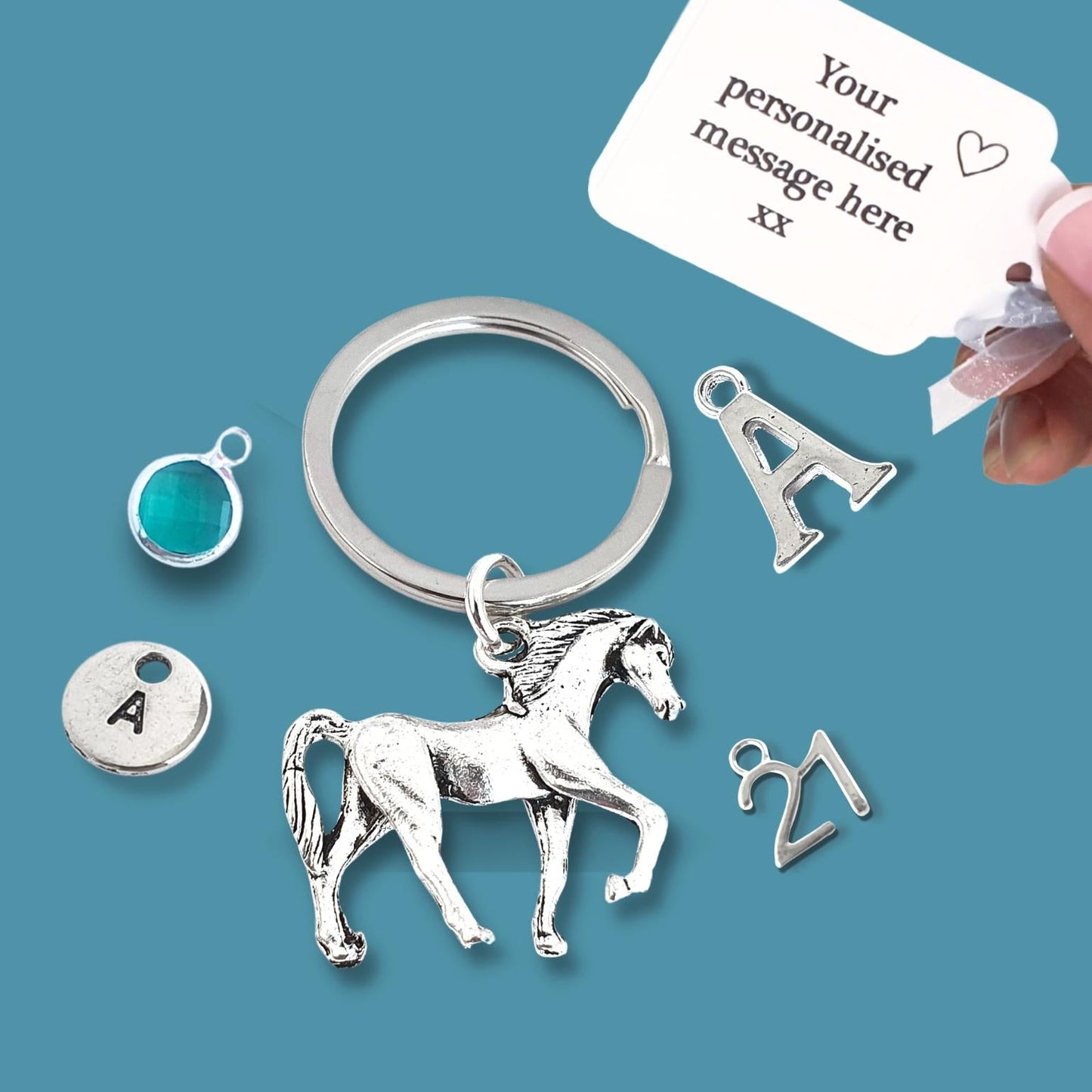 Silver horse keychain with customizable charms on a blue background