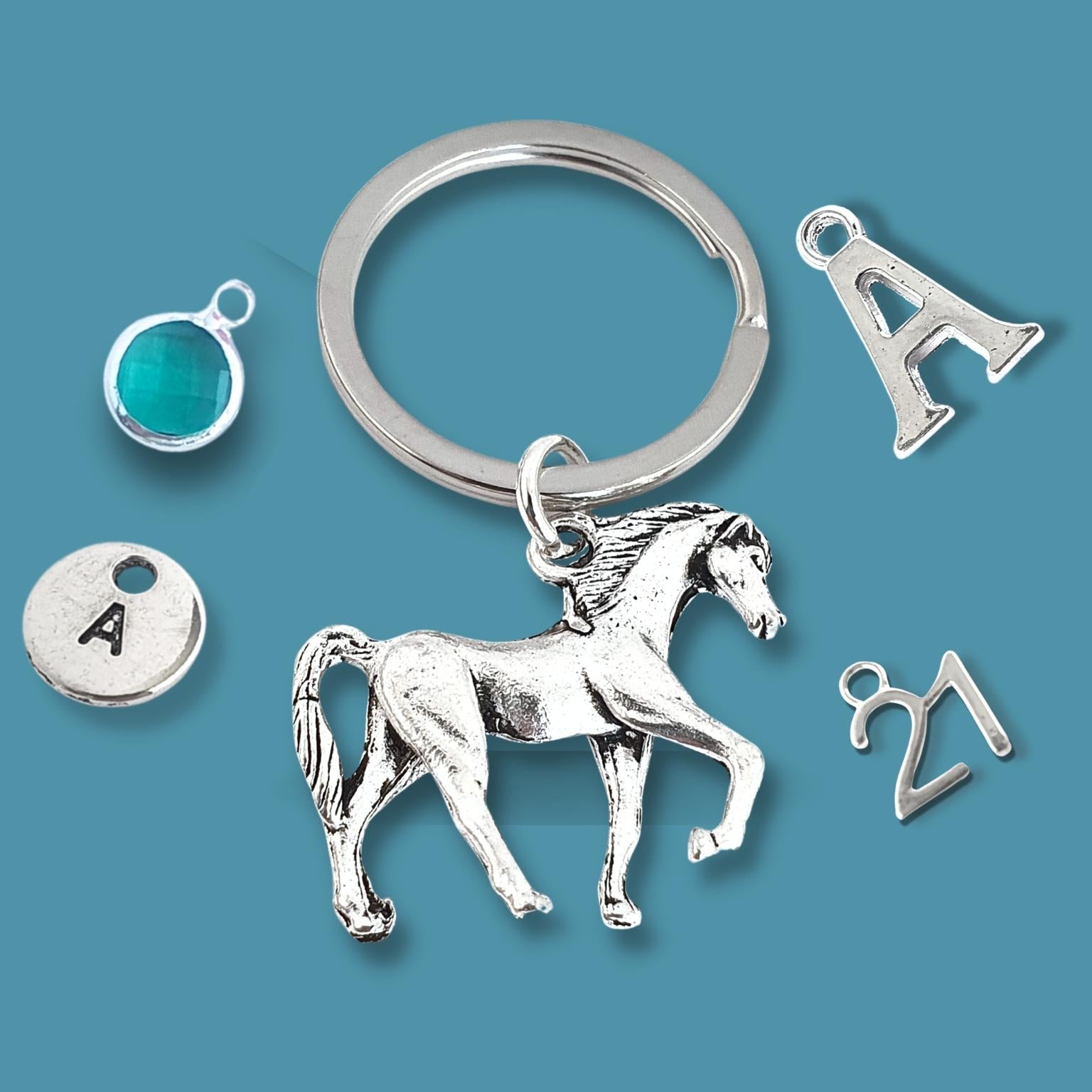 Silver keychain with horse charm and various other charms on a blue background