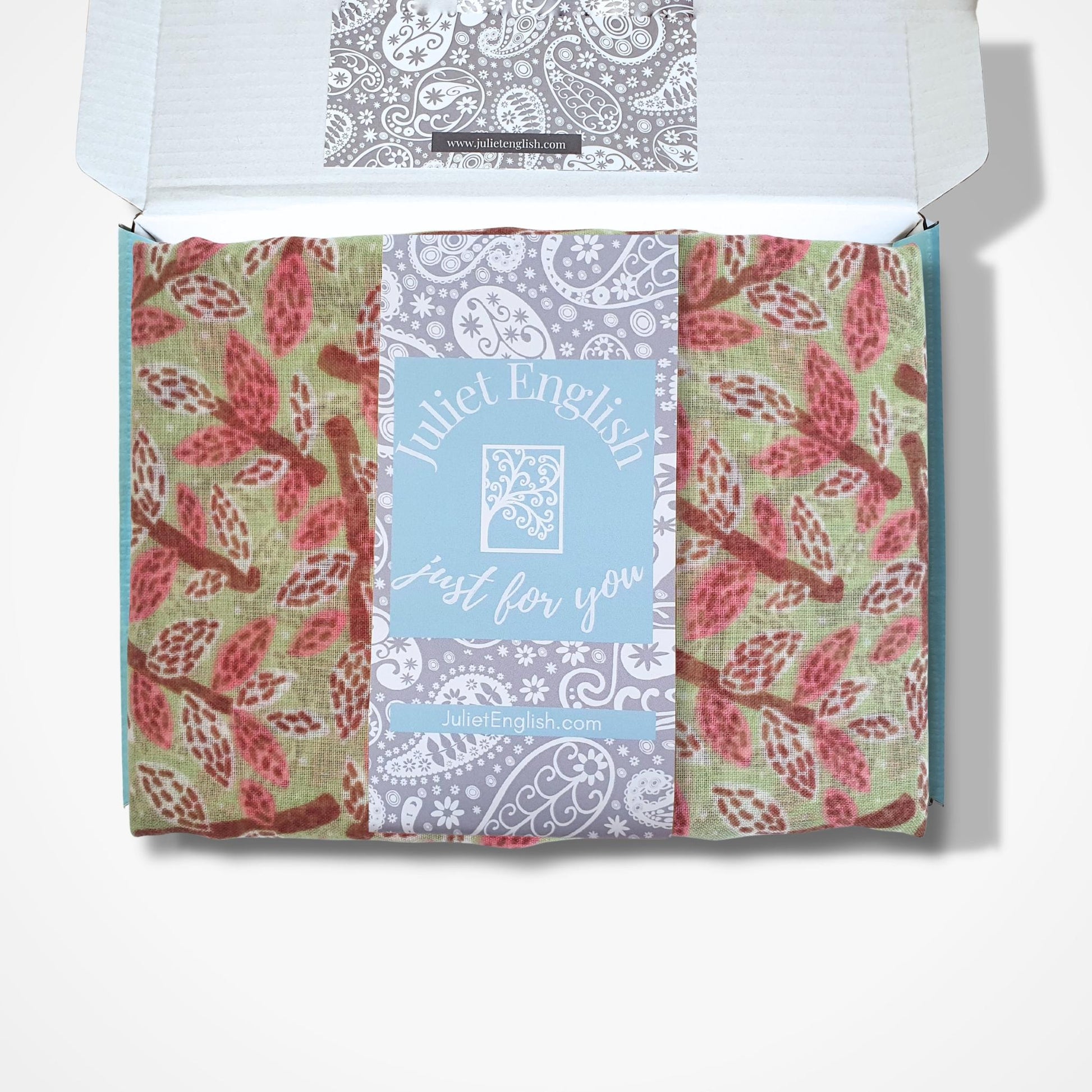 Packaged scarf with a leaf and branch design and 'Juliet English' branding on a white background