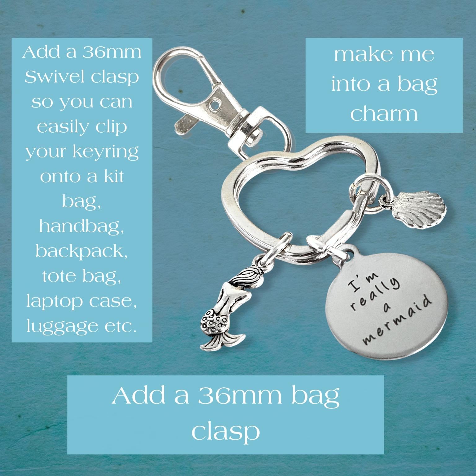 Silver keychain with heart-shaped clasp and mermaid charm on a blue background