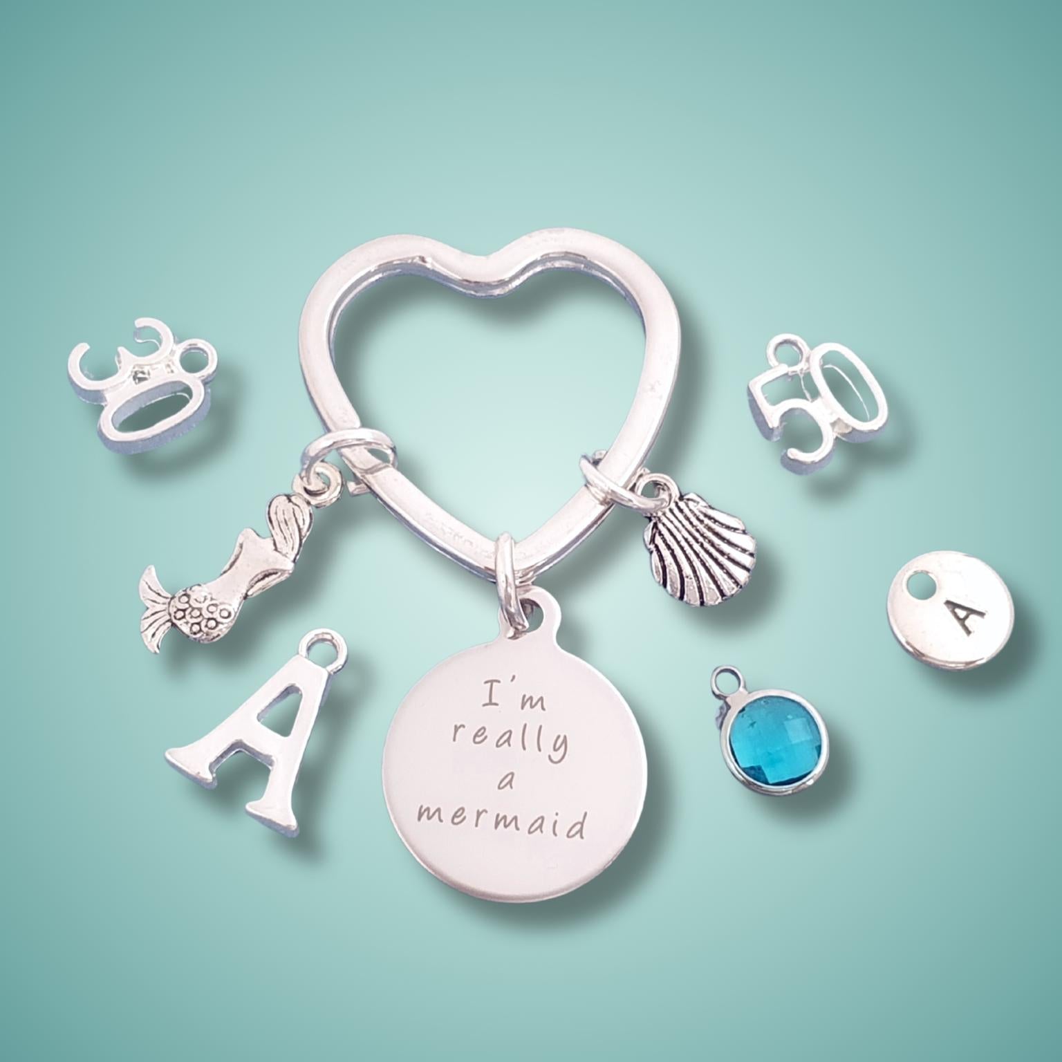 Silver charm keyring with various charms on a light green background