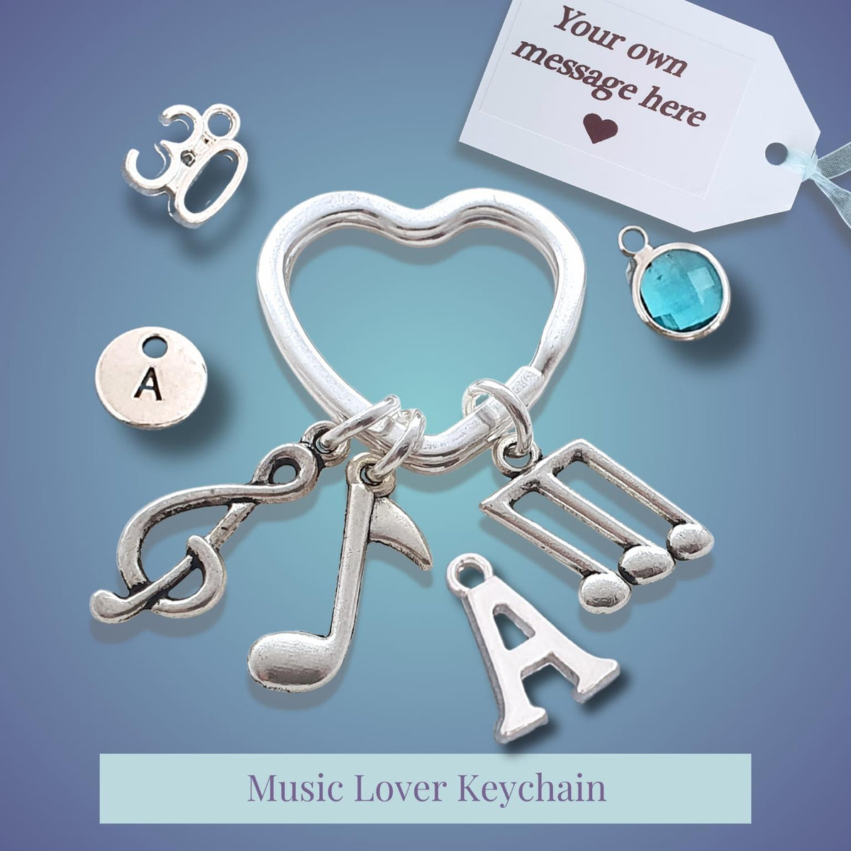 Silver music lover keychain with music note, heart, and letter 'A' charms, shown with customizable charm options and a gift tag on a blue gradient background.