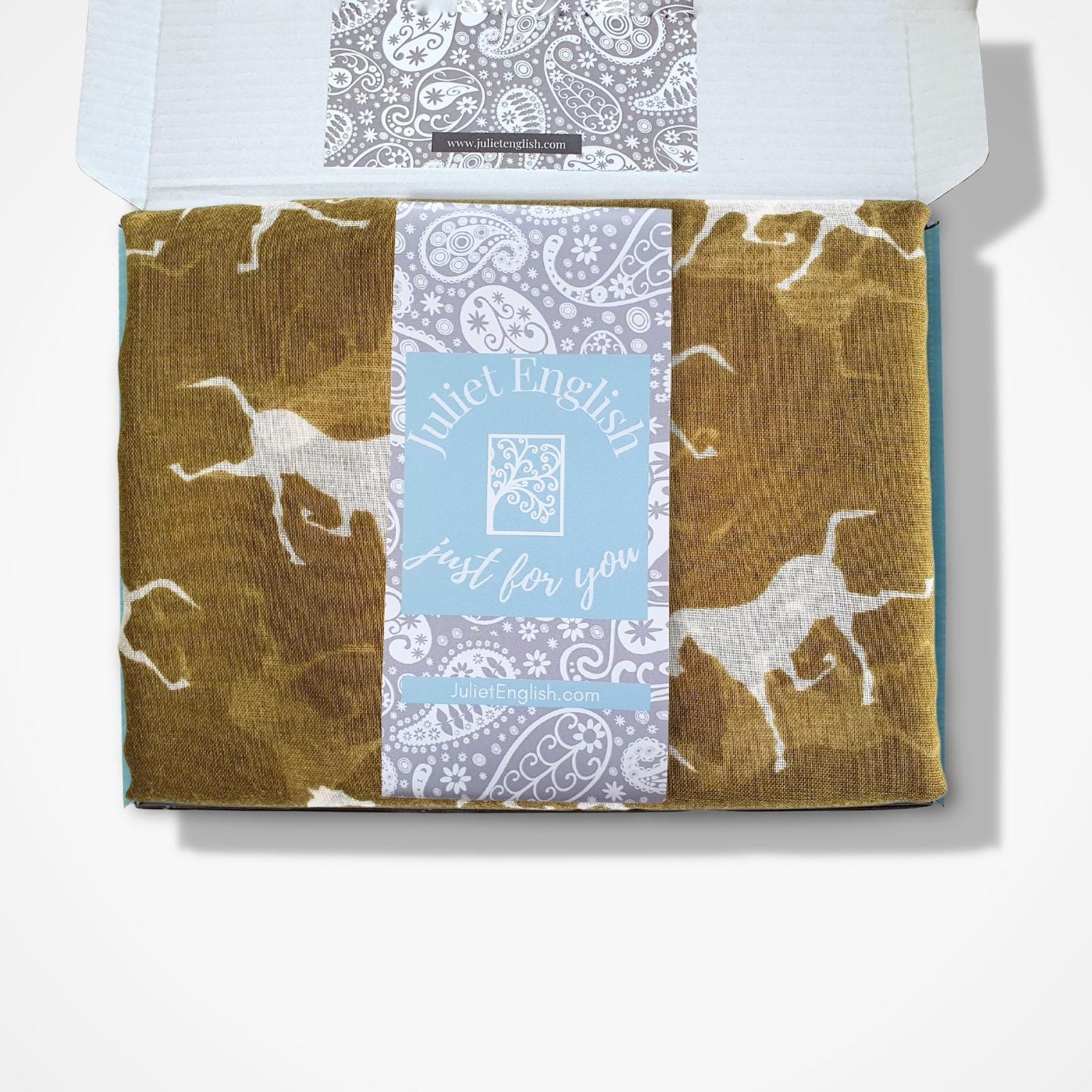 A boxed gift set from Juliet English, featuring a box with a central light blue label that reads 'Juliet English just for you'. The box contains a folded scarf in a yellow green with white horse print.